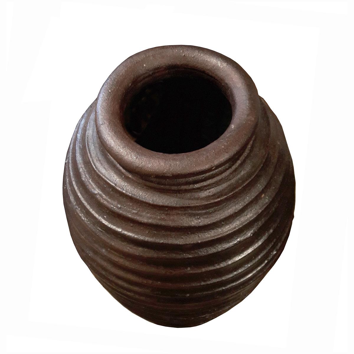 A tall clay jar or amphora, handcrafted in Indonesia, contemporary. Solid earthenware with rough ribbed finish, coated in brown glaze. Can be used as a decorative element or as a planter or cachepot, indoors or outdoors. 
