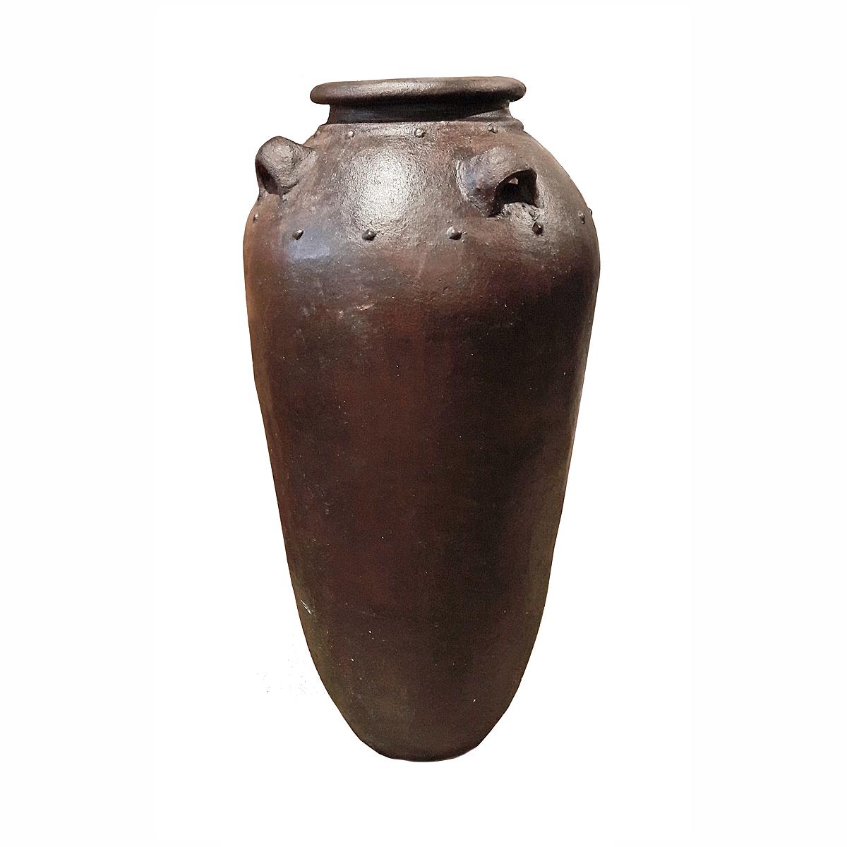 A tall clay jar or amphora, handcrafted in Indonesia, contemporary. Rustic finish in brown glaze. 4 ears. Can be used as a decorative element indoors, or as a planter or cachepot in outdoor spaces. 

Two available.