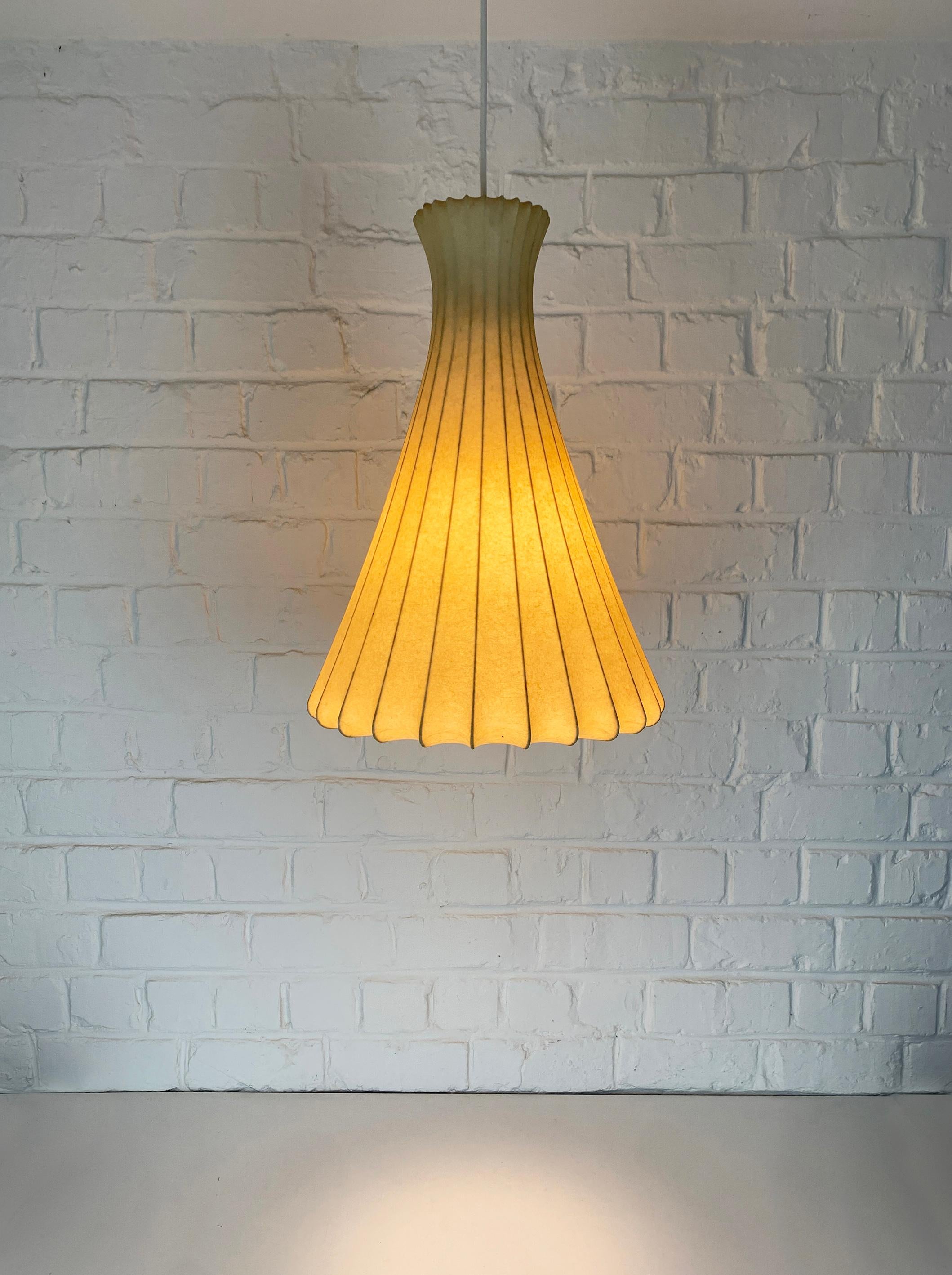 Tall Cocoon pendant lamp in a kind of Diabolo form. Design by Friedel Wauer. Manufactured by Goldkant Leuchten, Germany in the 1960s.

A thin steel framework covered with sprayed resin, which gives a Fiberglass look. The translucent resin gives a
