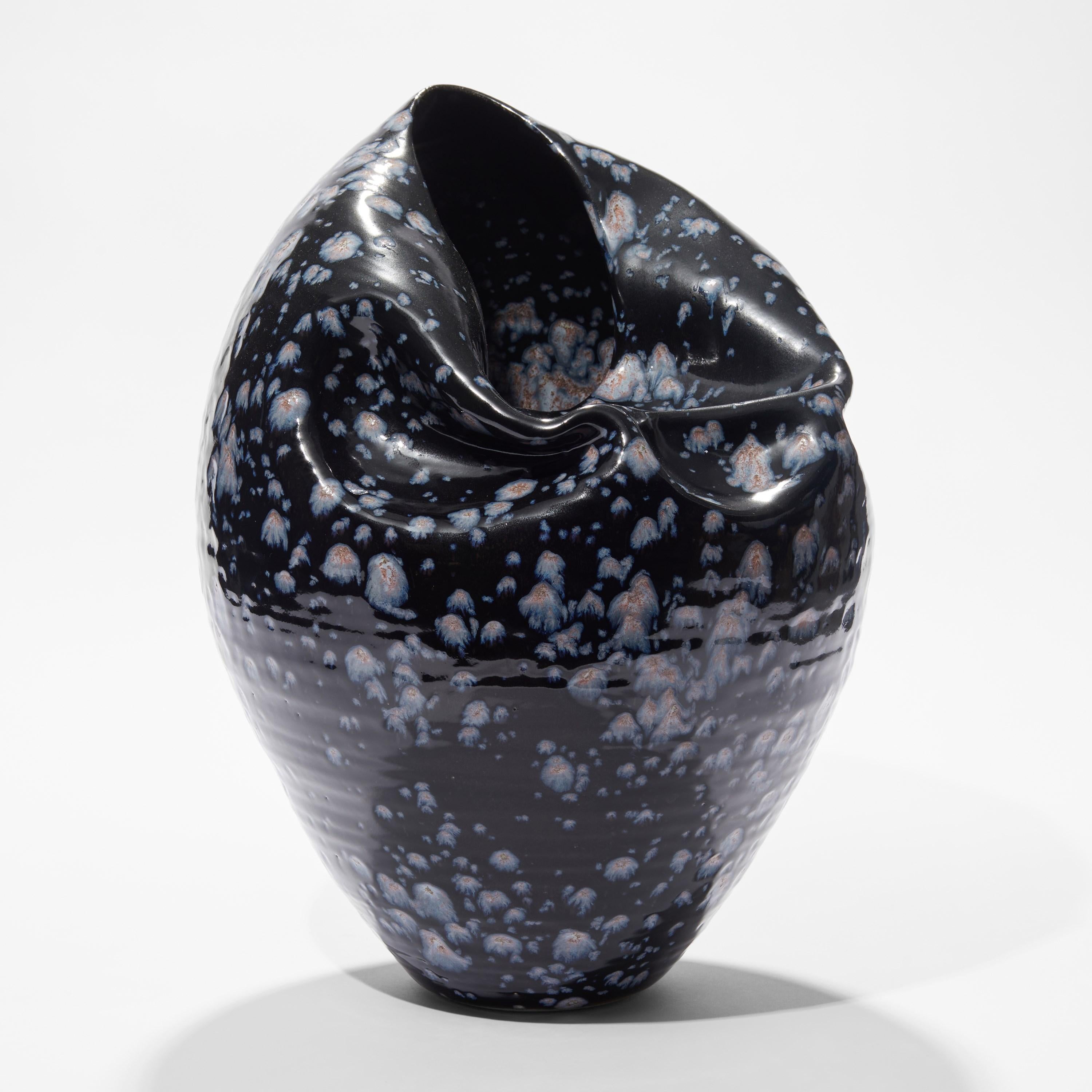 ‘Tall Collapsed Form in Galactic Blue No 92’ is a unique sculptural vessel by the British artist, Nicholas Arroyave-Portela.

Nicholas Arroyave-Portela’s professional ceramic practise began in 1994. After 20 years based in London, he moved and set