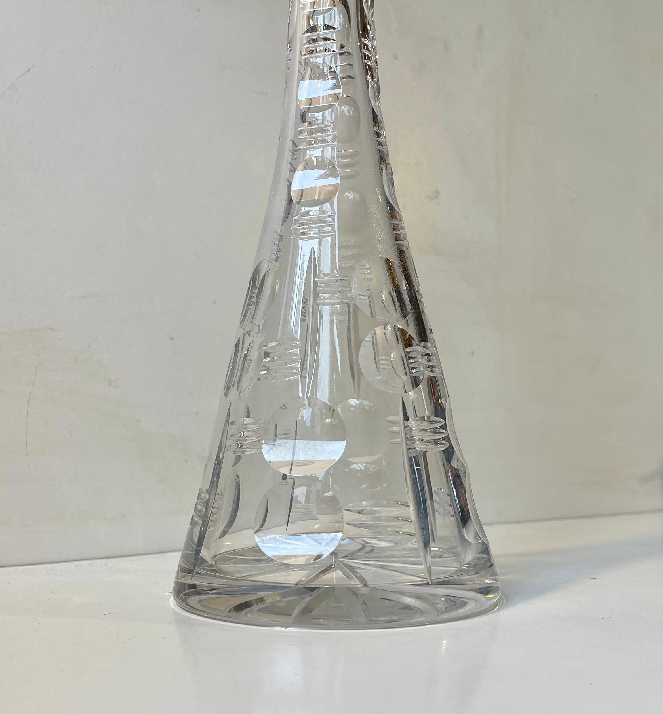 Jarra alta y bellamente tallada de cristal de los años veinte. Fabricado en Holmegaard, Dinamarca. La jarra está soplada a boca y cortada/pulida a mano con grandes puntos circulares pulidos y rayas geométricas. Recuerda mucho a piezas similares de