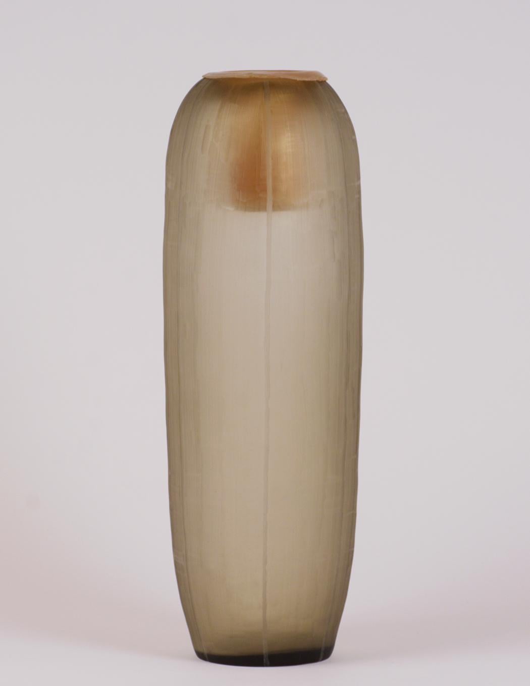This original Guax Glass Co. Tall Vase features a smokey amber color with an etched pinstripe design going from the top to the bottom of the vase. This vase comes with the original plastic liner and is in very good condition ready to be used for