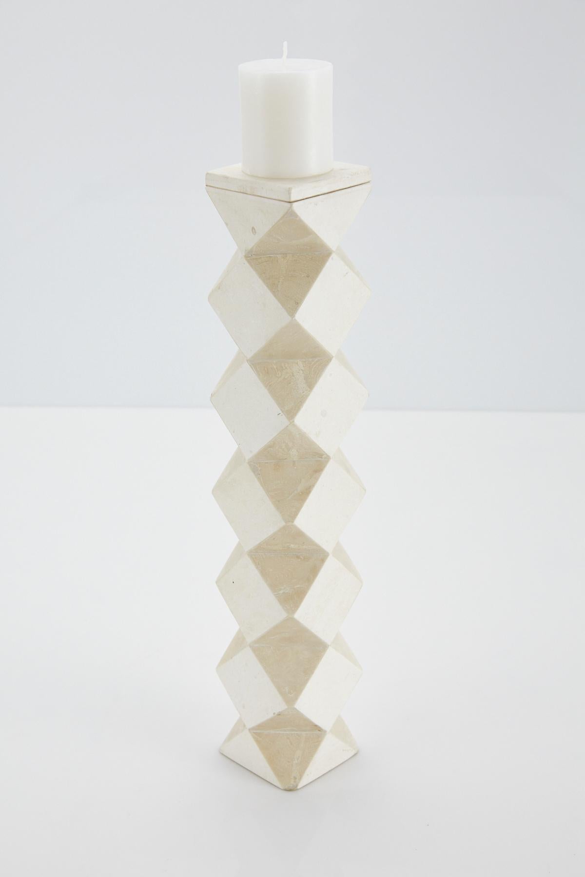 Tall pillar candleholder. Body is comprised of a rectilinear cube with faceted sides, alternating white and beige tessellated stone. The top of this convertible candlestick is removable and can then be used as a vase.

All furnishings are made from
