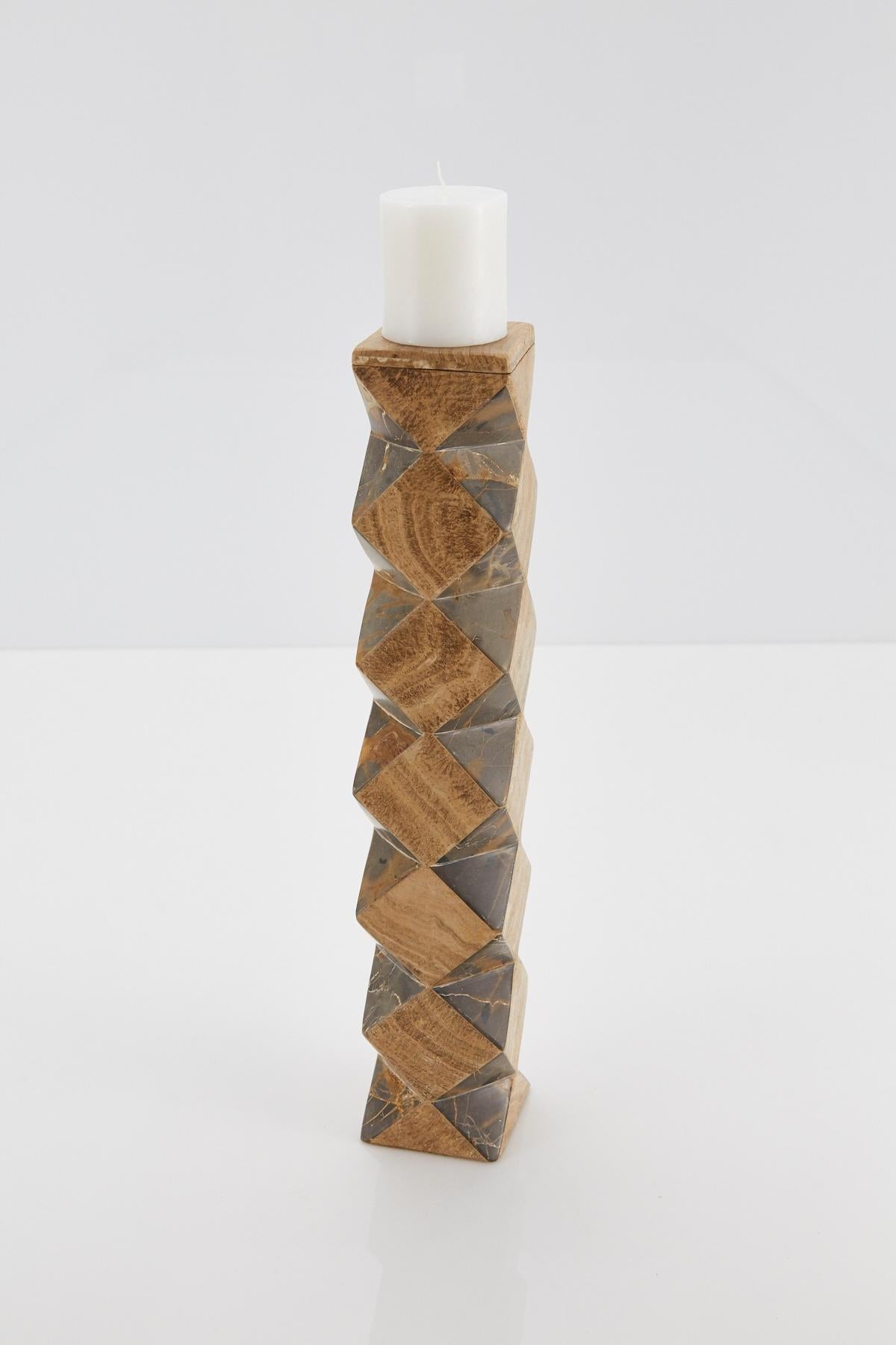 Tall pillar candle holder. Body is comprised of a rectilinear cube with faceted sides, alternating snakeskin stone and beige tessellated stone. The top of this convertible candlestick is removable and can then be used as a vase.

Coordinating short