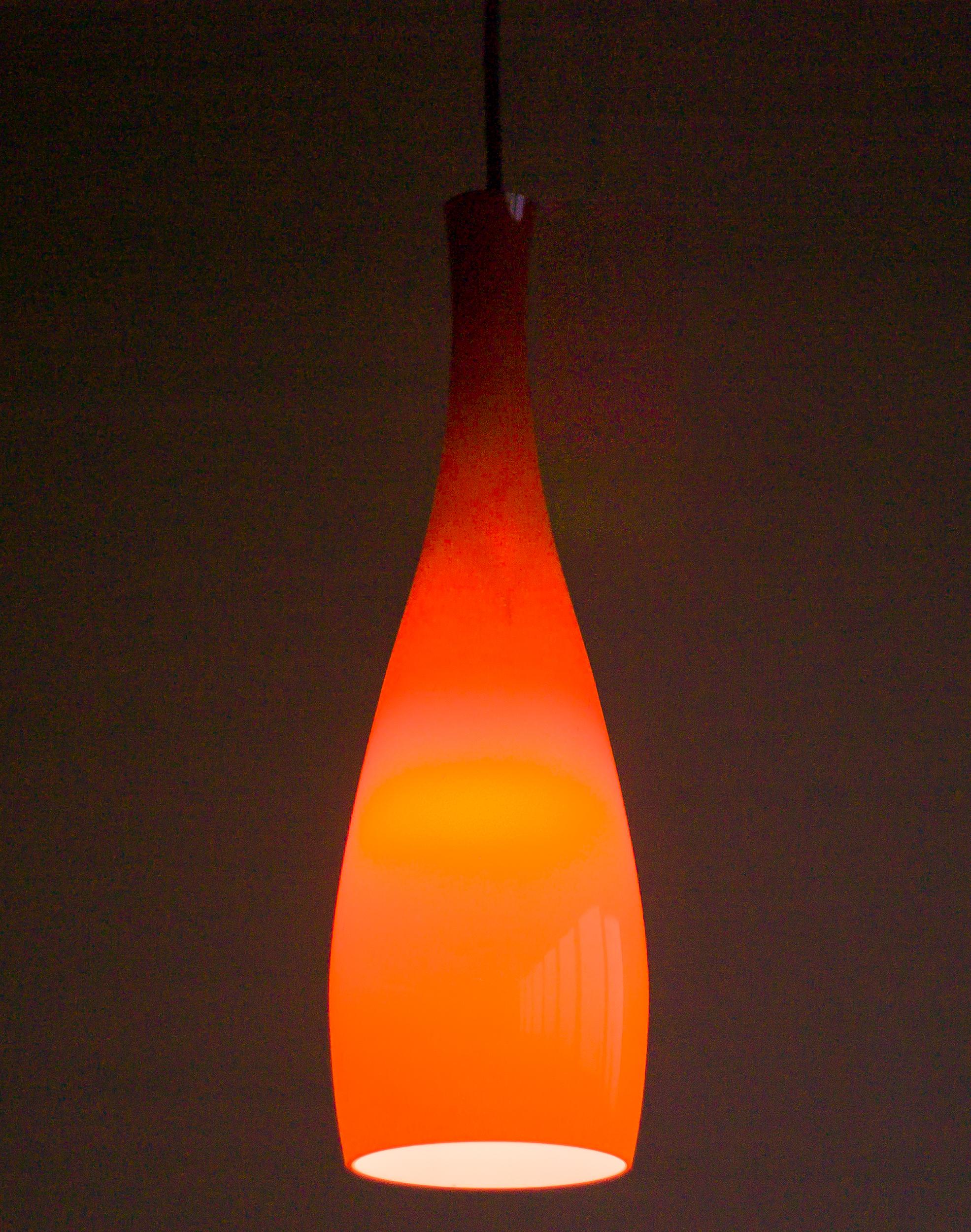 Tall coral colored opaline glass pendant designed in 1963 by Jacob E. Bang for Fog & Mørup, Denmark.

Jacob Bang was a Danish glass designer known for his innovative and high-quality designs. 
He was one of the leading figures in the Danish modern