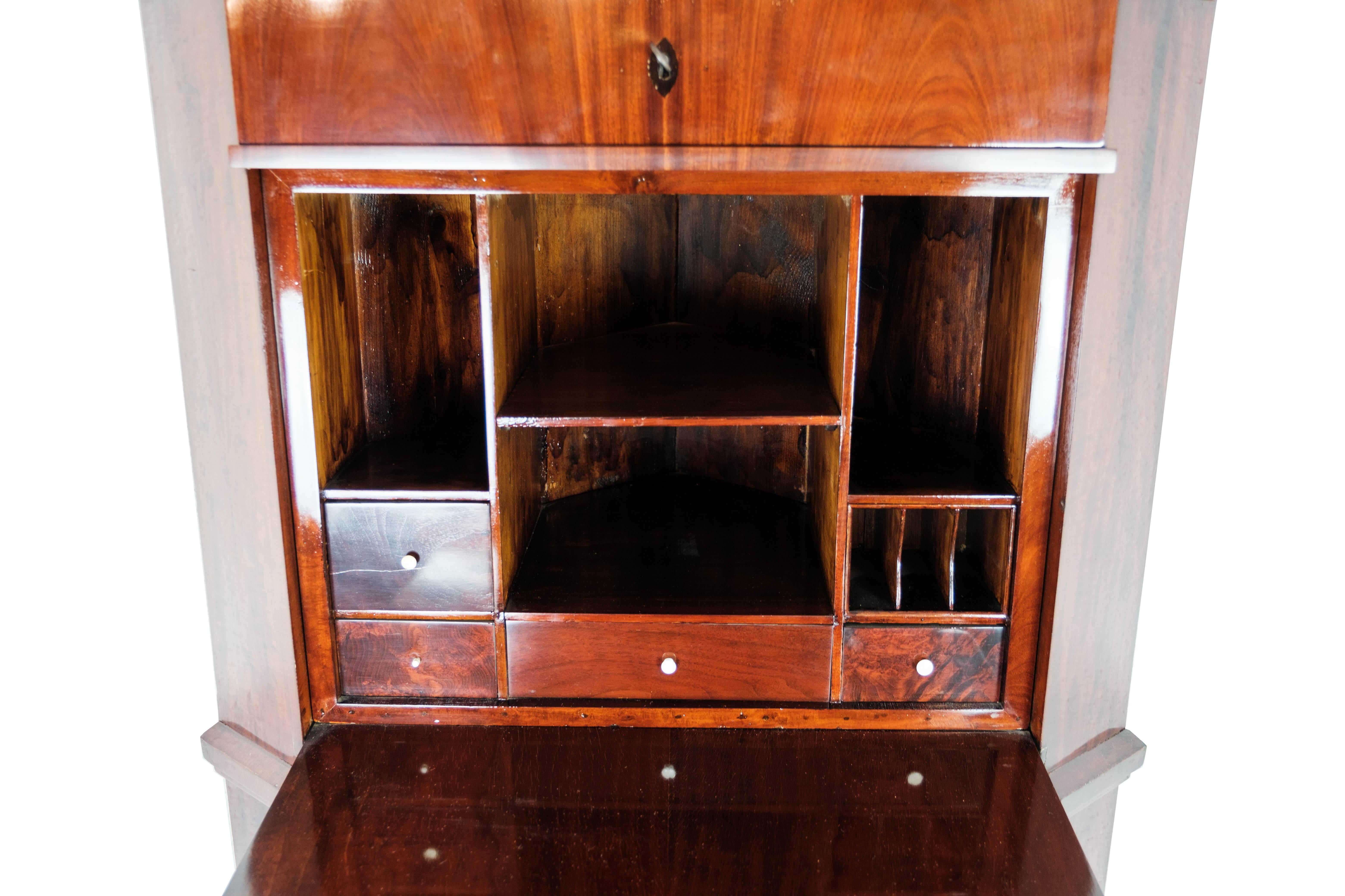 The tall corner cabinet/secretary in mahogany, in beautiful antique condition from the 1840s, is an impressive piece of furniture that exudes timeless elegance and historical charm.

The secretary, with its deep mahogany color and classic design, is