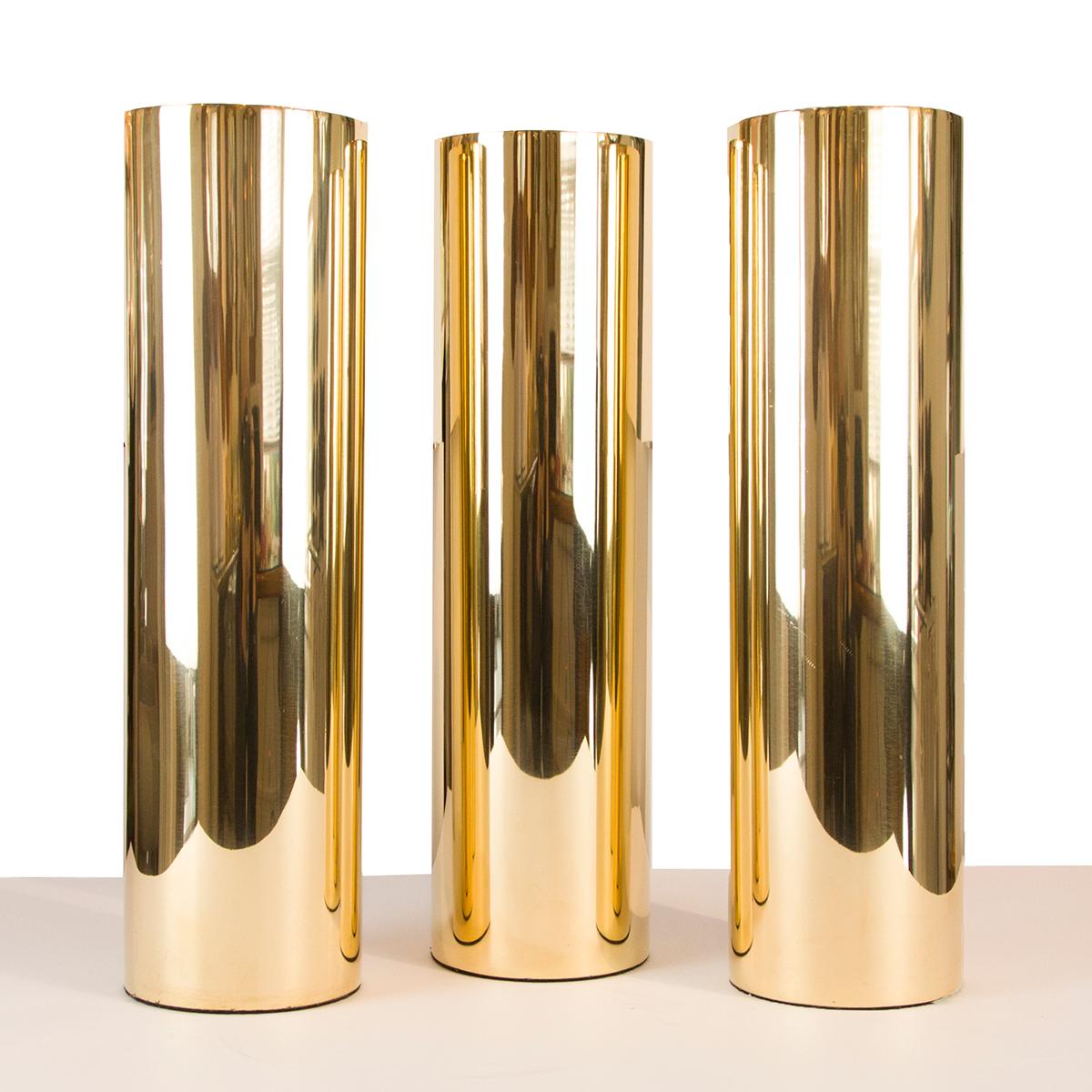 Tall cylindrical brass vase.
