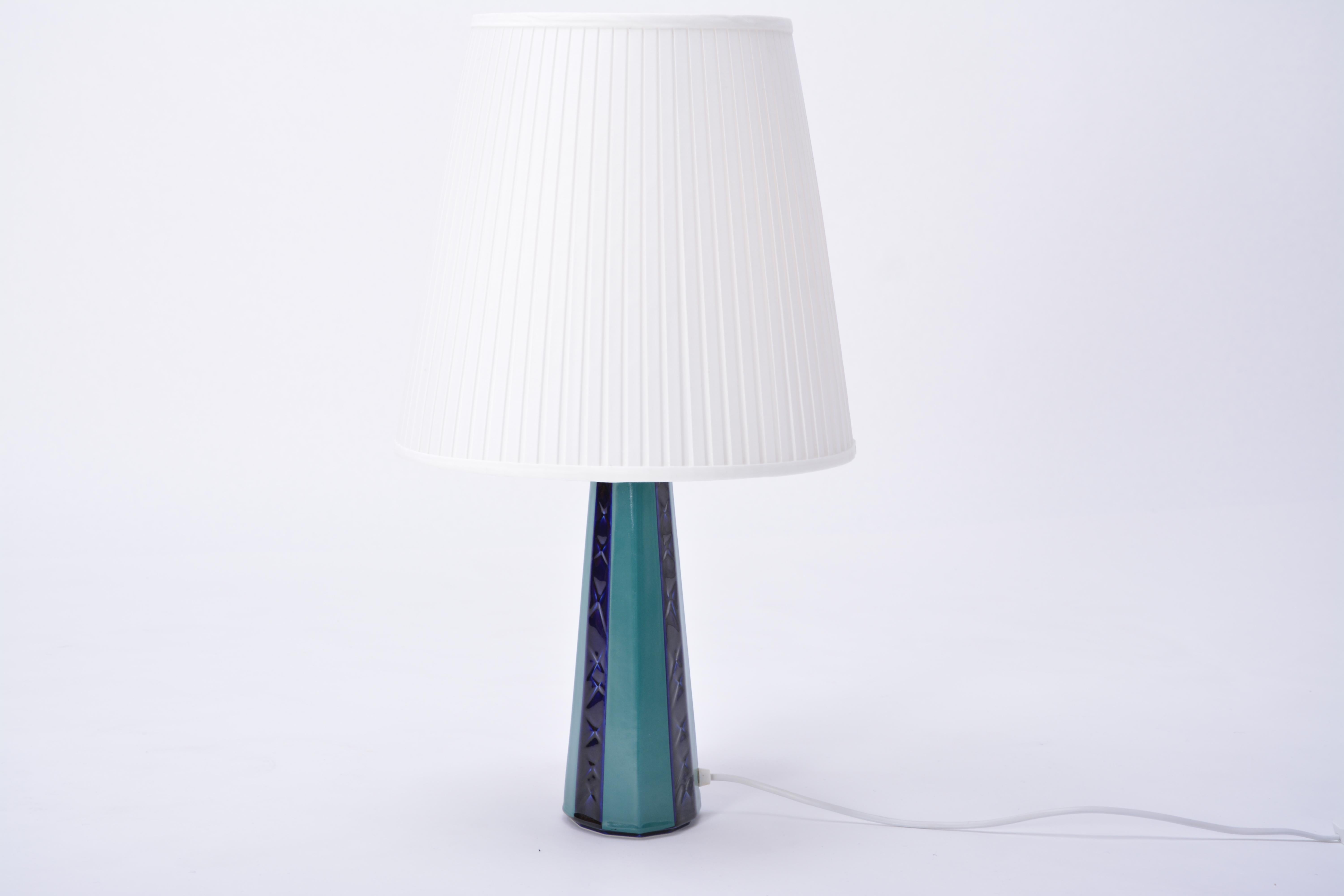 Diese Tischlampe aus Keramik wurde von der dänischen Firma Søholm hergestellt. Sie hat eine grüne und blaue Glasur und ein geometrisch geformtes Muster. Die Lampe wurde für den europäischen Gebrauch neu verkabelt und hat einen neuen Lampenschirm.