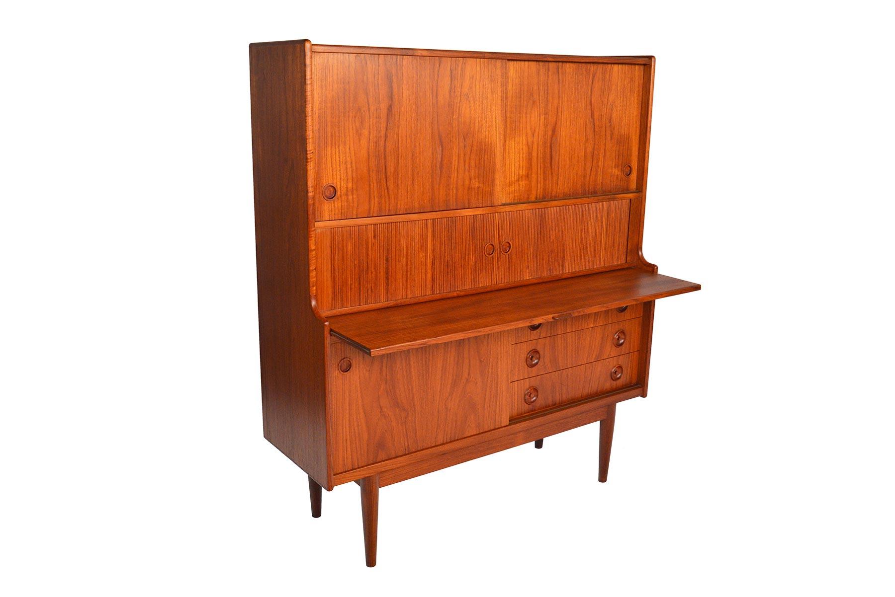 This tall Danish modern teak credenza by Johannes Sørth for J. Skaaning and Søn is outfitted with all the bells and whistles! Two upper sliding doors open to reveal two bays with three drawers and two adjustable shelves. The center features two