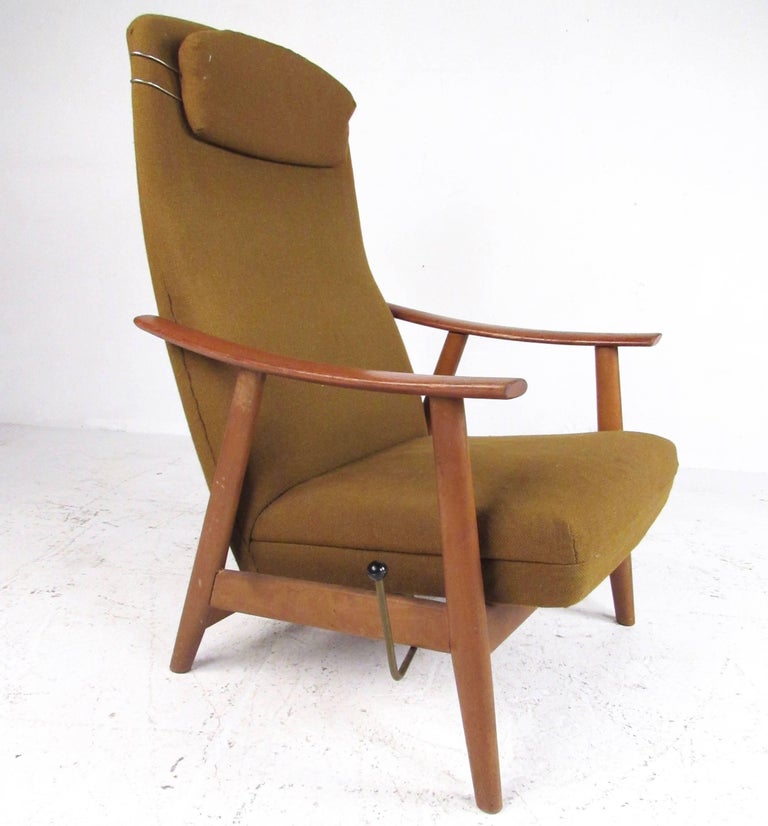 This beautiful Mid-Century Modern lounge chair features teak hardwood frame and high back upholstered seat. Adjustable reclining option locks the chair into varying angles for optimum comfort. Striking addition to home or office seating area. Please