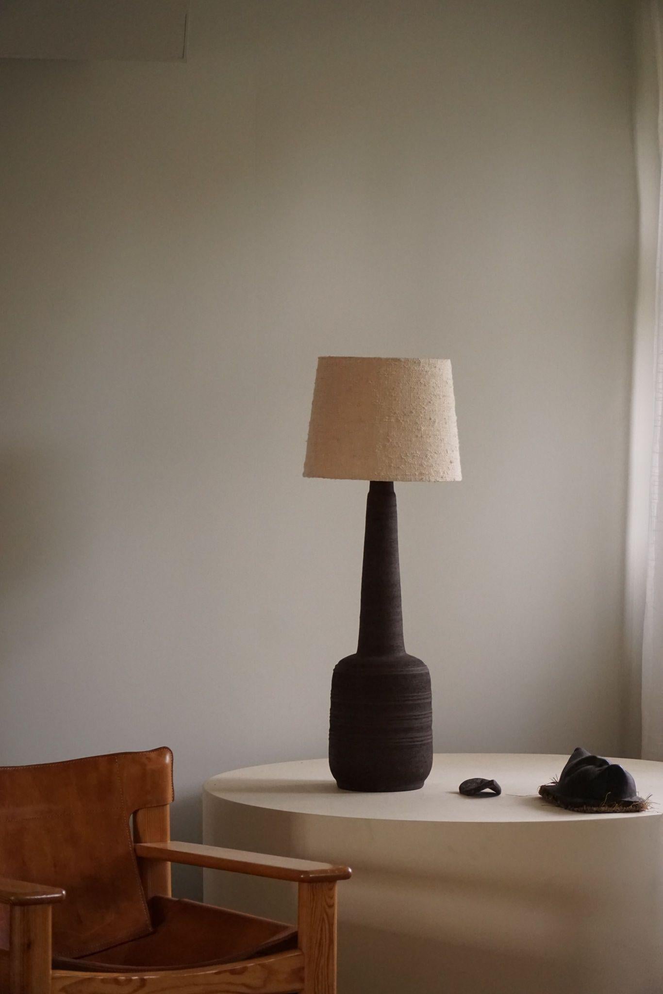 A rare tall Danish Mid-Century Modern brutalist stoneware lamp in a beautiful vintage condition. Dark earthen colors. Crafted in Denmark in the 1970s.

A beautiful vintage lamp well suited for the Modern or Scandinavian lifestyle.

NB: Sold without