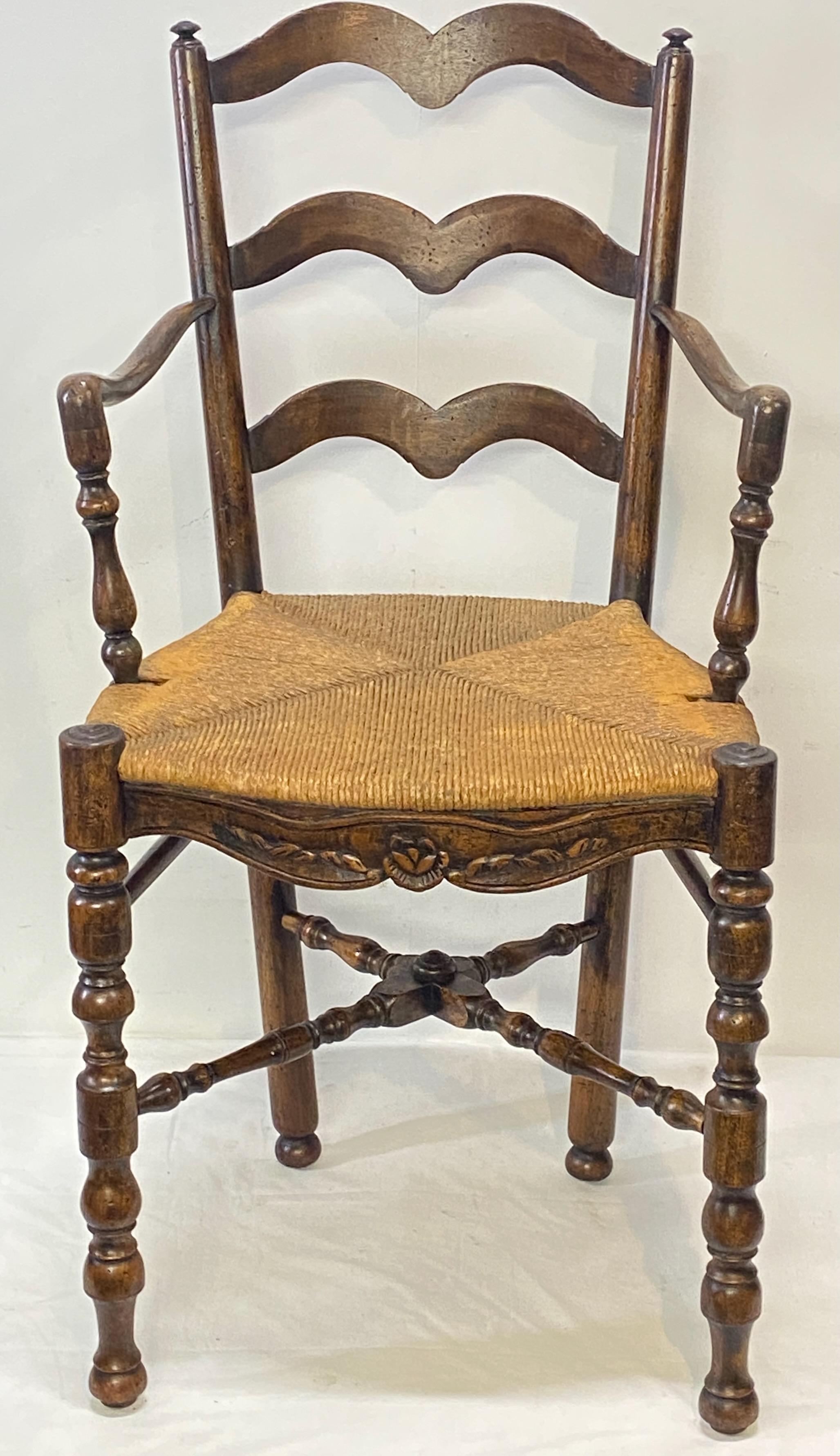 A very unusual tall French Provincial carved walnut ribbon back armchair with a fancy x stretcher and old if not original rush seat. In excellent antique condition and very sturdy. 
France, early 19th century.
