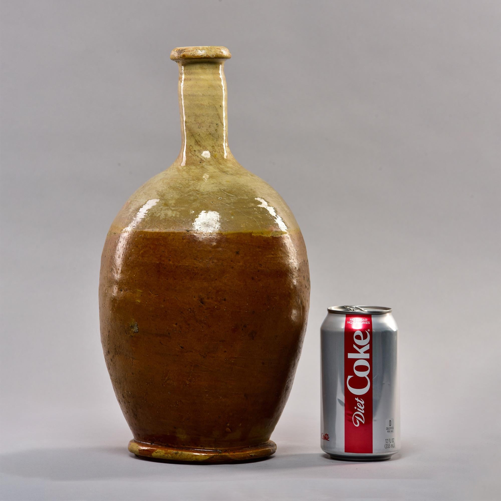 Grand vase en céramique française rustique datant d'environ 1900, dans des tons terreux, avec une glaçure plus claire sur le col et les épaules et un brun plus foncé sur le corps et la base. Fabricant inconnu.
