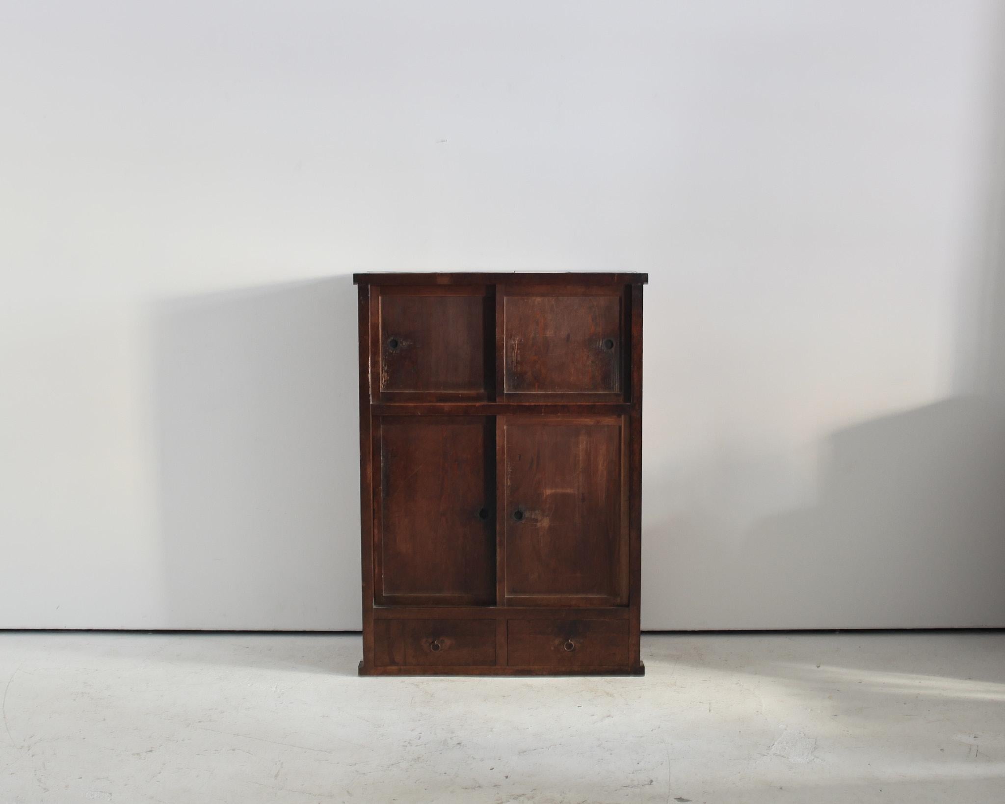 A tall heavily patinated cedar Japanese Tansu cabinet.

Featuring four sliding doors & two drawers (with one internal shelf).

Strong utilitarian design.