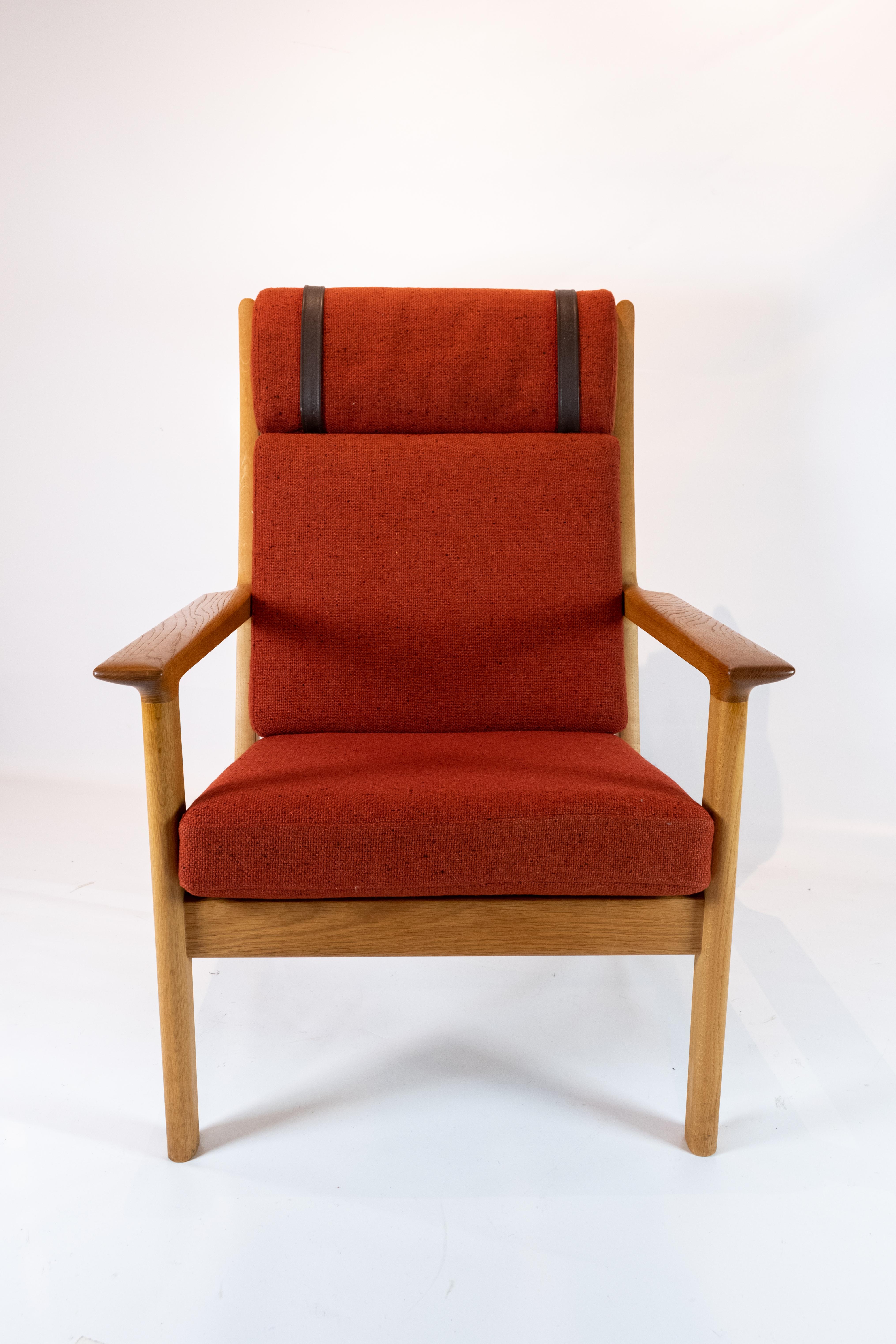 A high armchair in oak and red wool fabric, designed by the legendary Danish furniture architect Hans J. Wegner and manufactured by Getama in the 1960s.

This impressive armchair is an icon of Danish furniture design and represents the best of the
