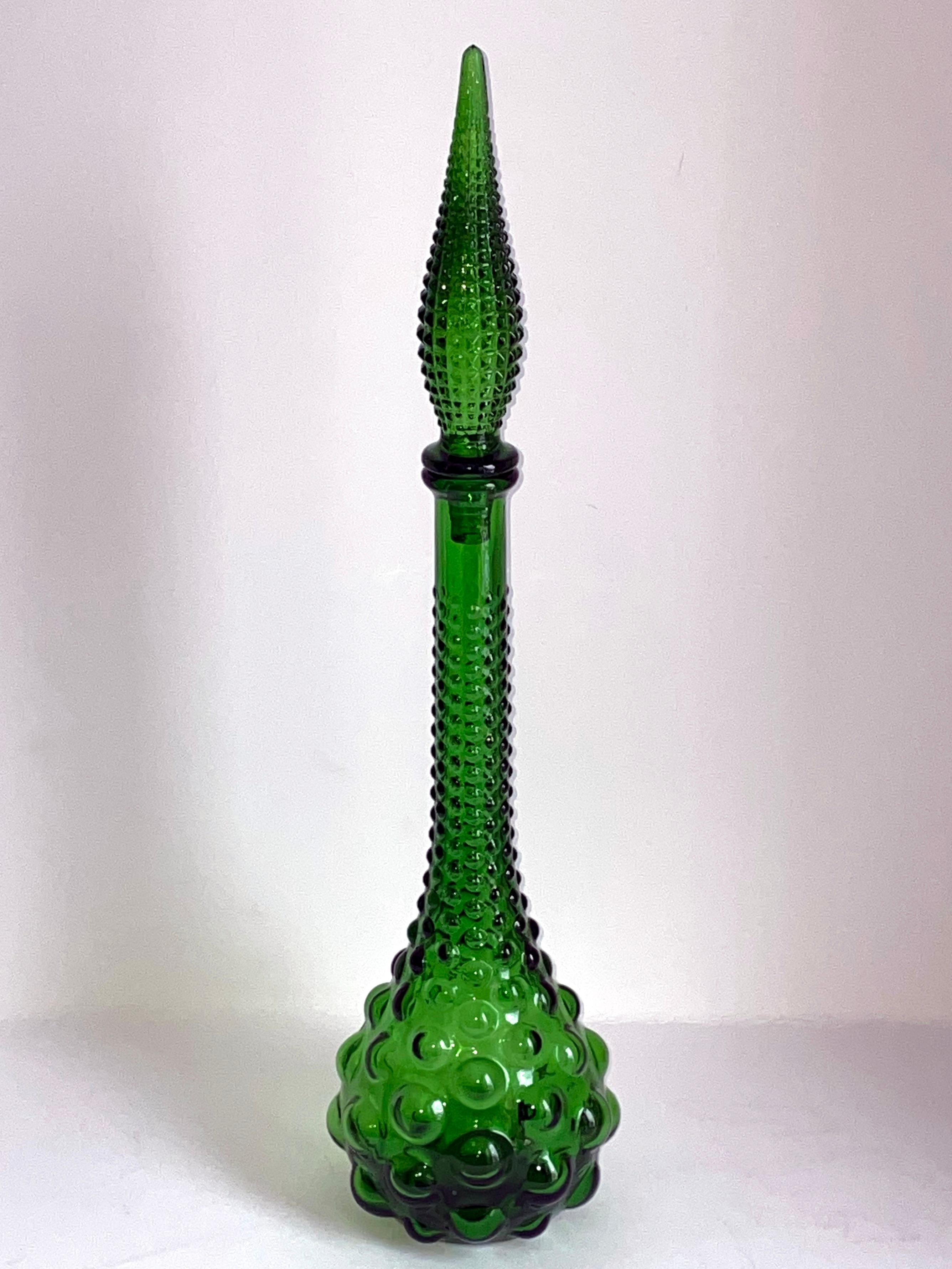This vintage Italian Mid-Century Modern large glass genie bottle features a raised bubble pattern and a rich and mesmerizing emerald green color. Probaly manufactured by Empoli, it dates from the 1960s. Height: 53 cm with stopper.
  