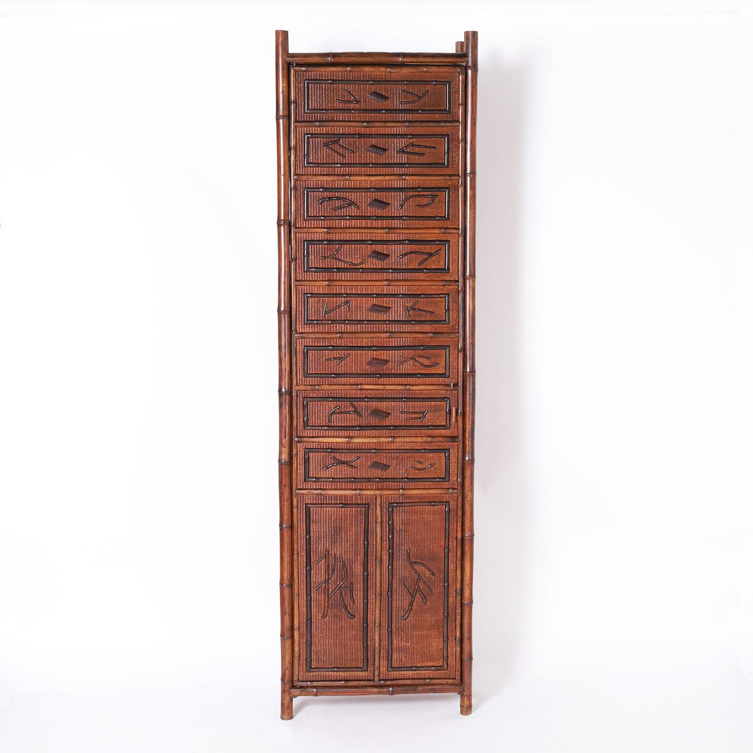 Tall handsome 19th century English cabinet crafted in a bamboo frame with grasscloth panels over wood with applied bamboo Japanese characters and borders. The interior is lined with a lovely Asian style floral wallpaper.