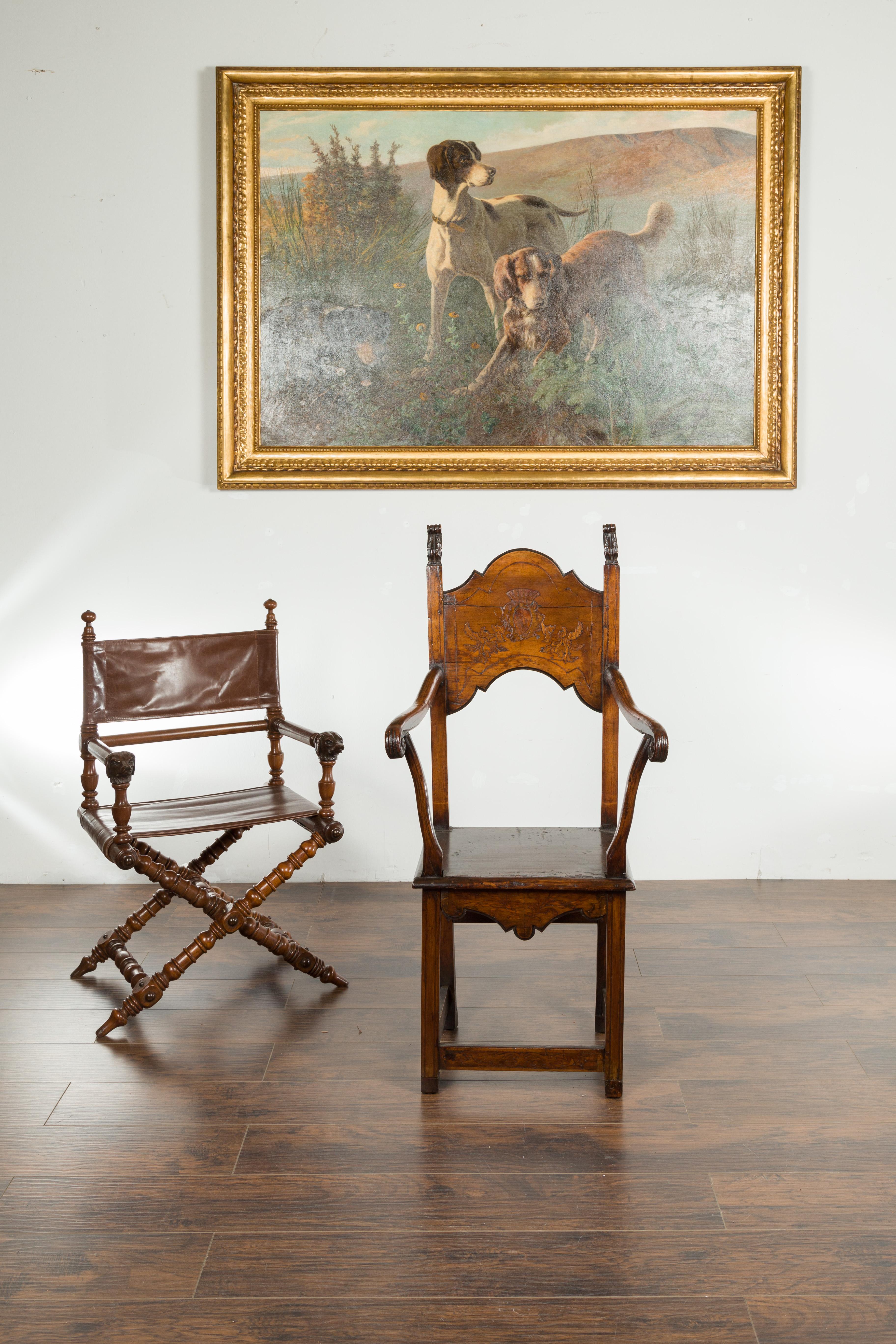 An English Georgian period tall wooden chair from the early 19th century, with carved cartouche and scrolling arms. Created in England during the first quarter of the 19th century, this wooden chair charms us with its tall back, carved with foliage
