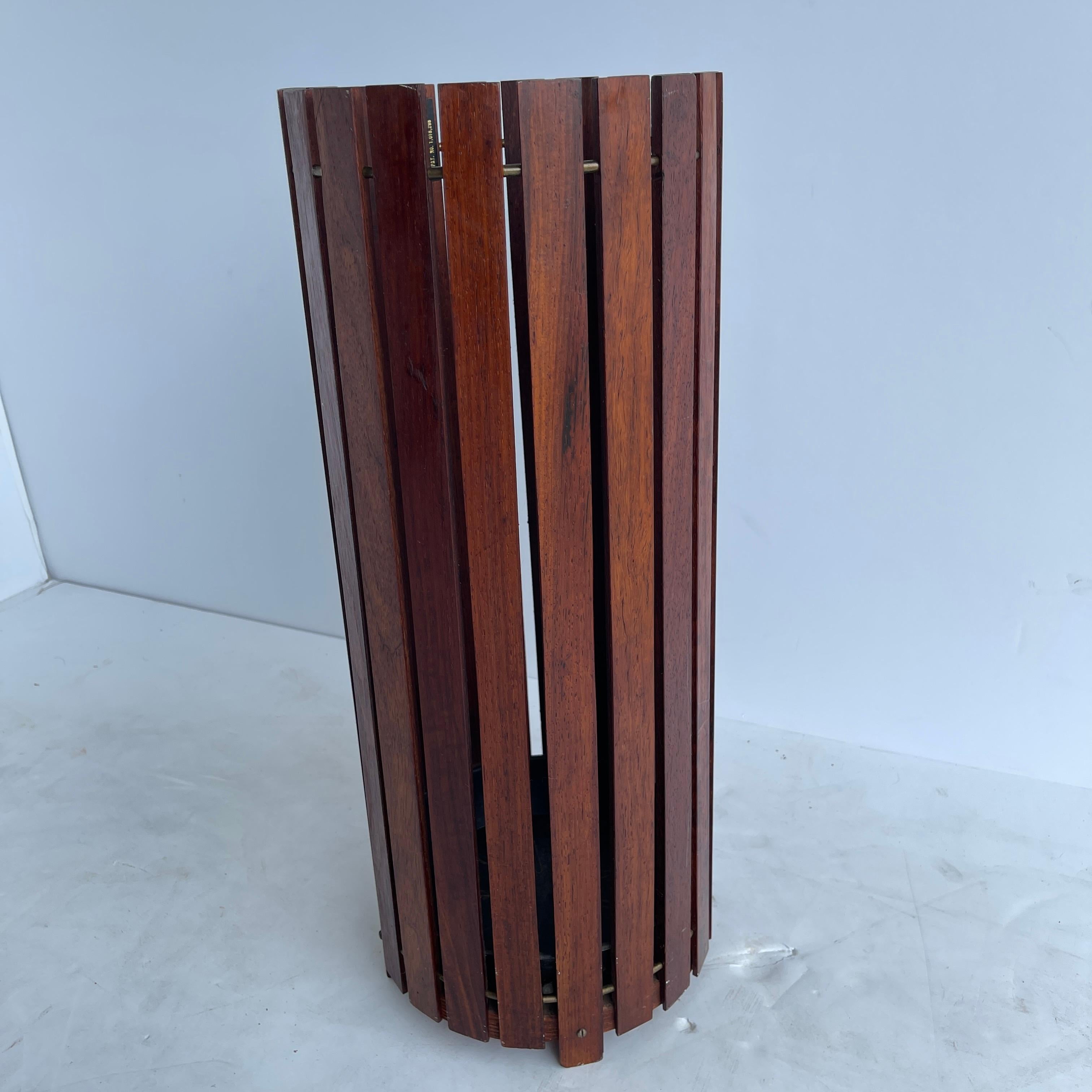 Mid-Century Modern walnut umbrella stand, England circa 1960's.
Tagged made in England by Gladlyn Ware, this lovely and sturdy umbrella stand has rich walnut slats separated by brass rods. In good vintage condition, the umbrella stand will be a