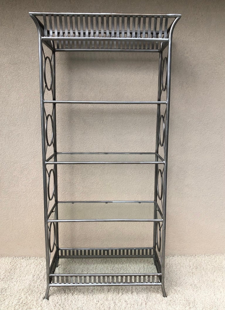 Tall Maison Jansen style Hollywood Regency, steel and glass etagere, elaborate hand made, with decorative top and base .unique size and scale. 5 glass shelves in all, vintage patina and condition. Silver tone to metal.