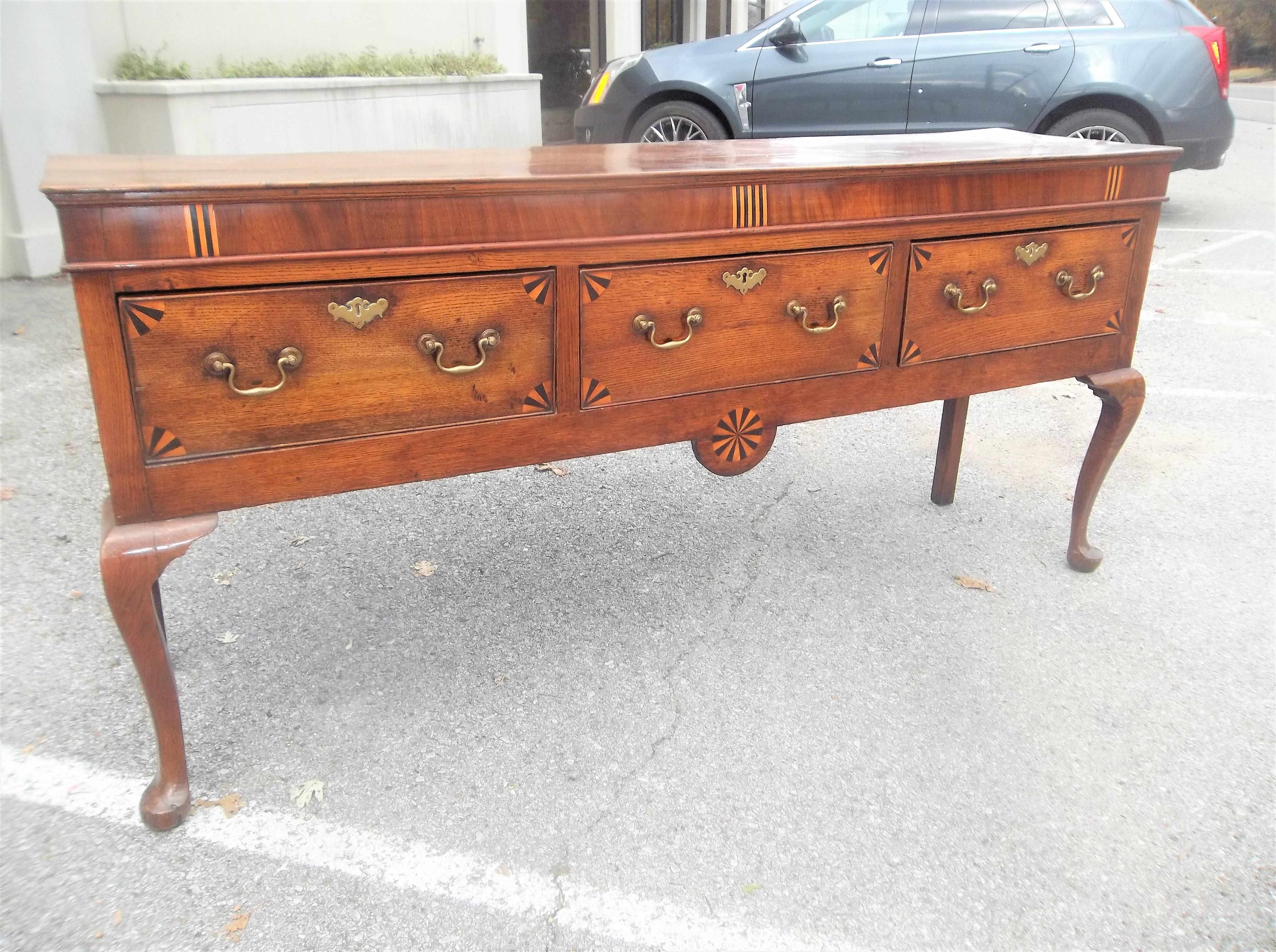 With inlaid mahogany banding and fan inlaid drawers. Tall for a dresser base, more of sideboard height. Hand-cut dovetail to each drawer. Nice warm cognac / walnut color. Typical use stains to the top. Some fading to drawer fronts.  Solid boards