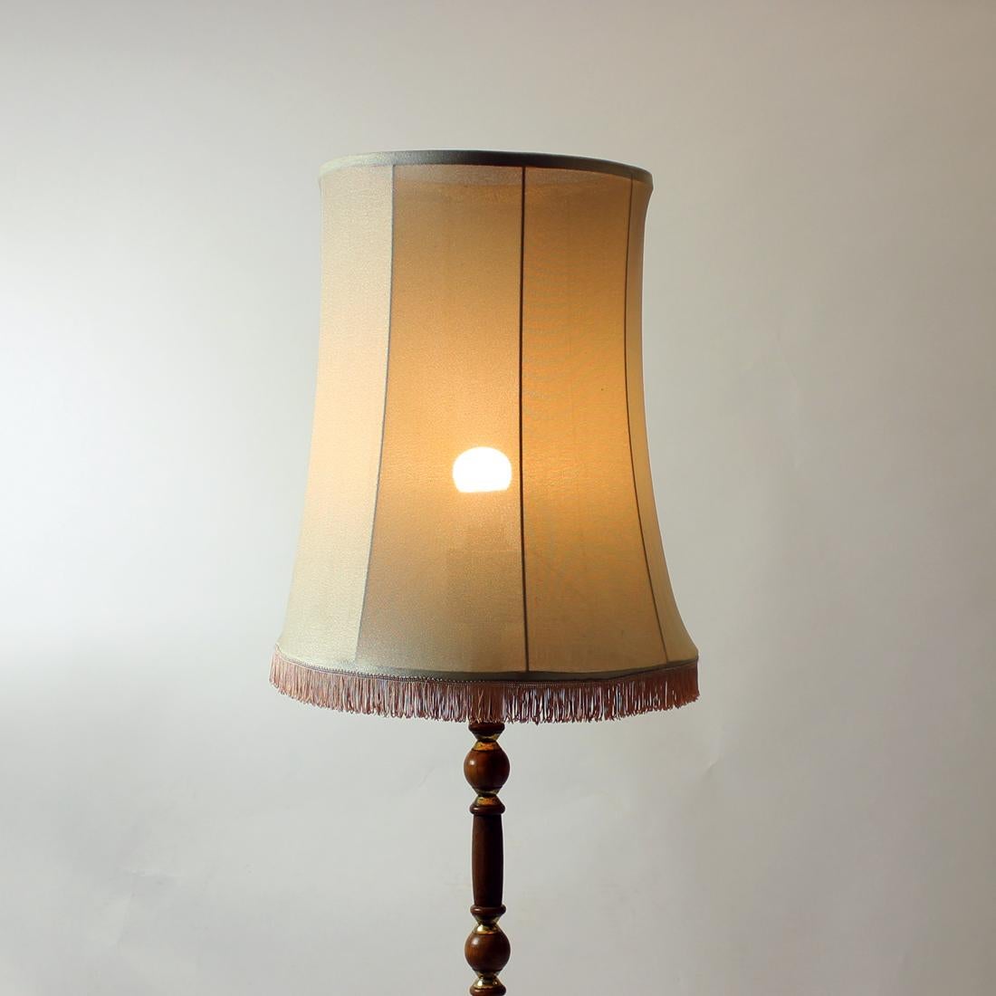 Beautiful floor lamp with a lot of original style. Produced in Czechoslovakia in 1950s. The lamp stands on a strong construction with three legs. It is made out of oak wood in combination with brass details. Beautiful style. Original shield of the