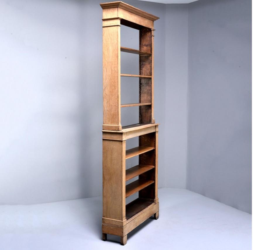 Elegant 1920s French bleached oak tall narrow bookcase or étagère features a decorative pediment, carved reeded supports, an open back and adjustable shelves. Bookcase breaks down to two pieces for transport. 

Measures: Bottom piece height