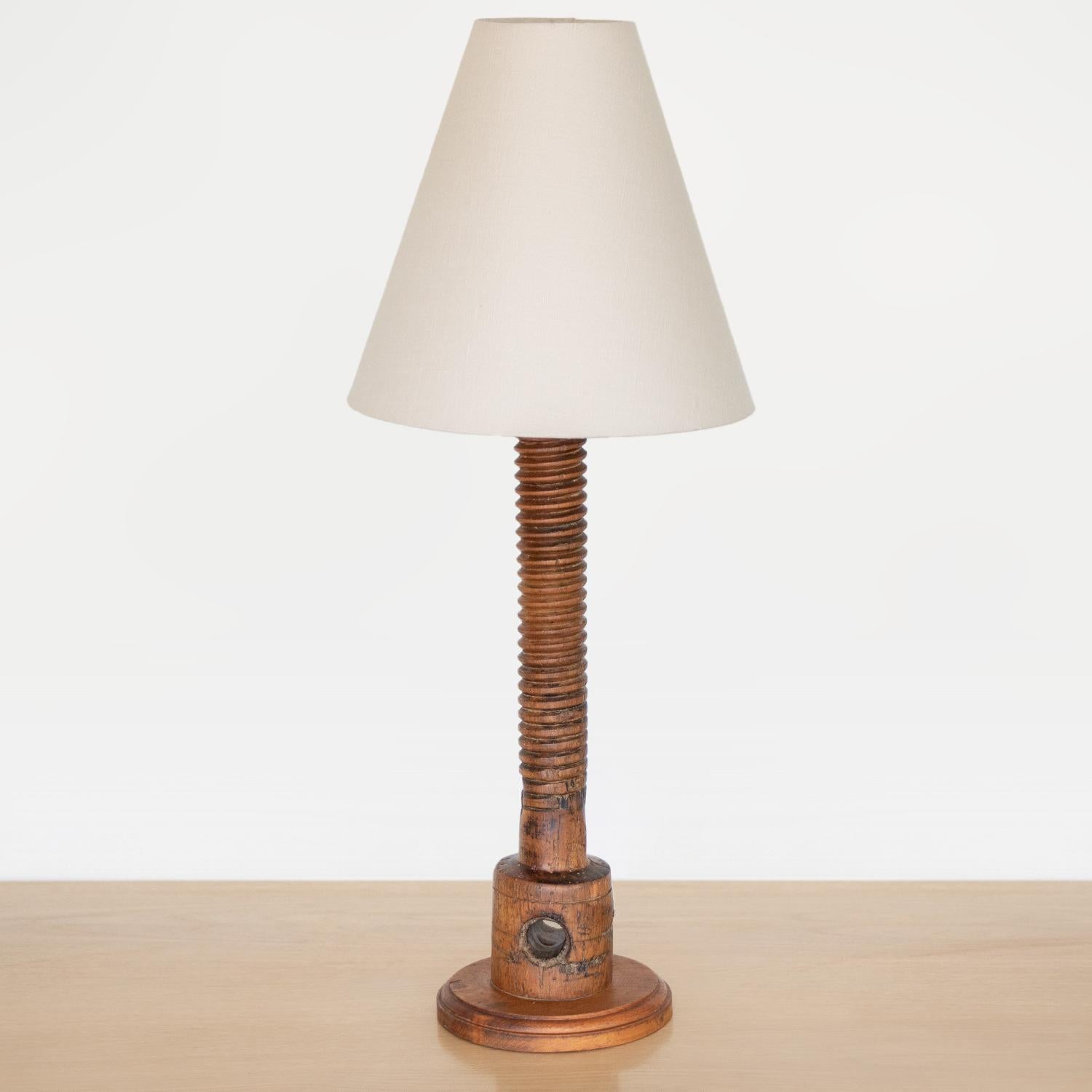 Tall hand carved wood table lamp from France, 1940s in the style of Charles Dudouyt. Twisted carved wood stem with wood block base and carved hole. Original wood finish showing nice age and patina. New tapered linen shade and newly re-wired. Takes