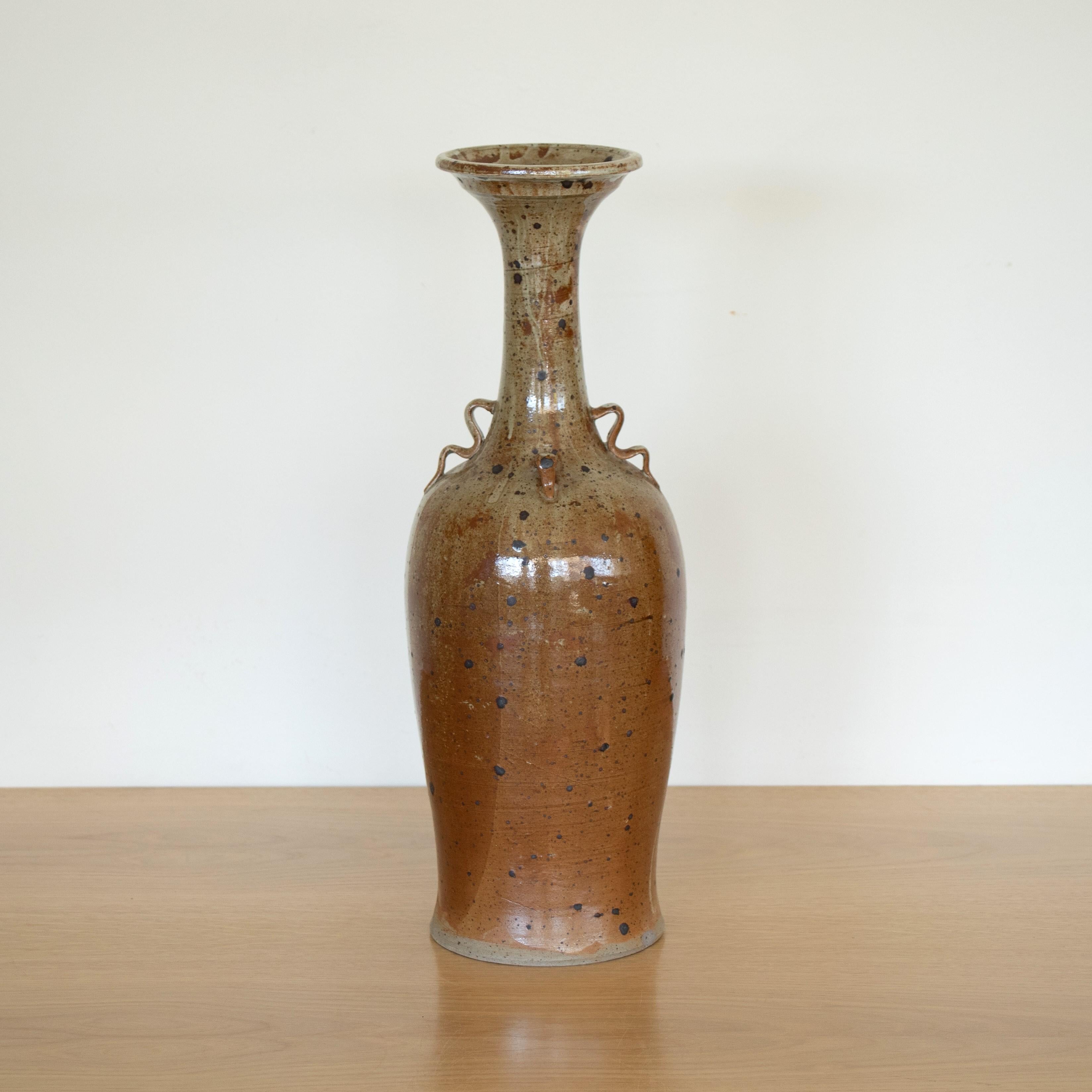 Beautiful tall ceramic vase from France. Natural tan glaze with brown specks and squiggle handle detail. Impressive vintage piece, perfect as a decorative object or vase. 