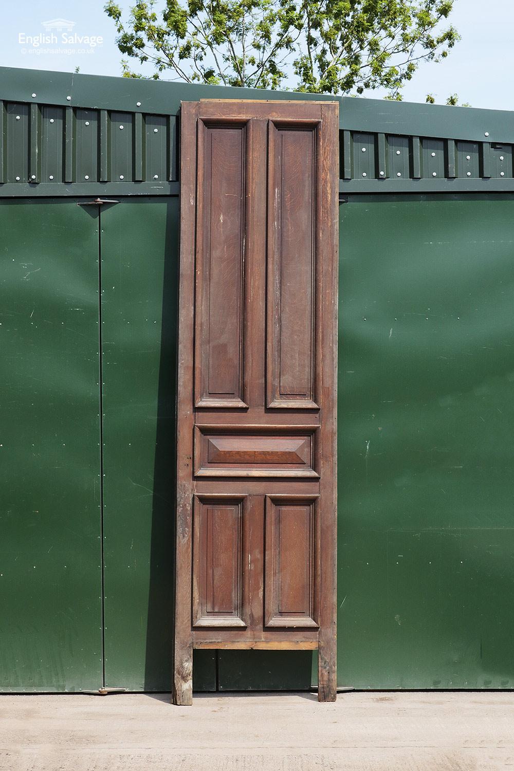 Reclaimed tall oak panel with five beaded panels, the central horizontal panel with a raised section, and a plain back. Ideal as a cupboard door or piece of wall paneling. Damage to the bottom of the door, including a missing kick plate and nail