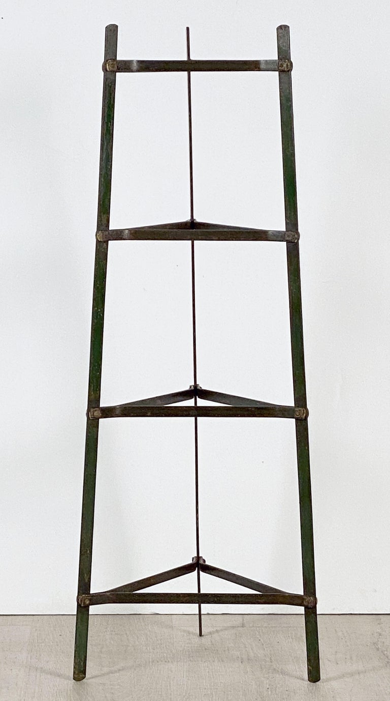 A fine French pan or pot stand of painted metal, featuring four triangular fitted tiers on a tripod support for the display of cookware.

Can be used for garden pots and other decorative uses as well.