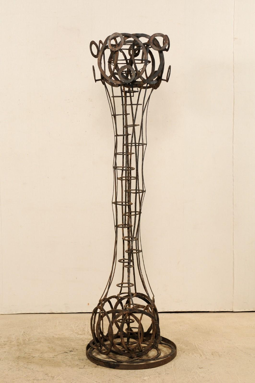 A tall French sculptural iron art piece in a motif of rings from the 1930s-1940s. This unique sculpture from France, standing at approximately 6.6 feet in height, has a playful abstract vertical form made up of a series of rings, with circles