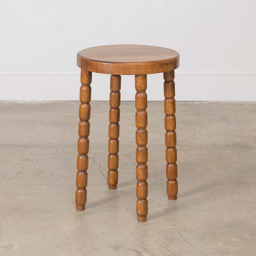 Unique vintage wood stool from France, 1950s. Circular seat with four carved ribbed legs. Original wood finish with nice age markings and patina. Can be used as a stool or as side table next to chairs.