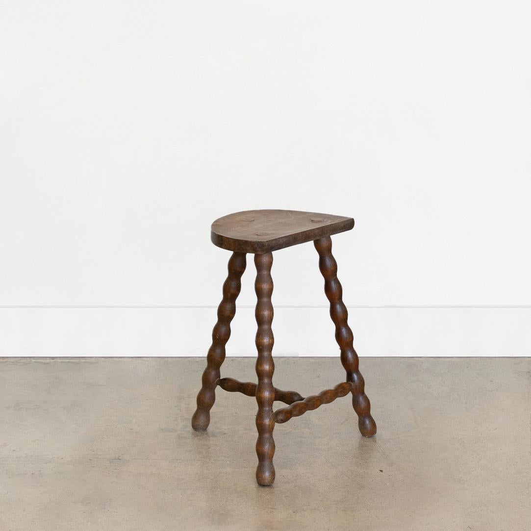 Vintage tall wood stool with semi-circle seat and wavy tripod legs from France. Original wood finish with great age markings and patina. Can be used as a stool or as side table. Measures 17.75