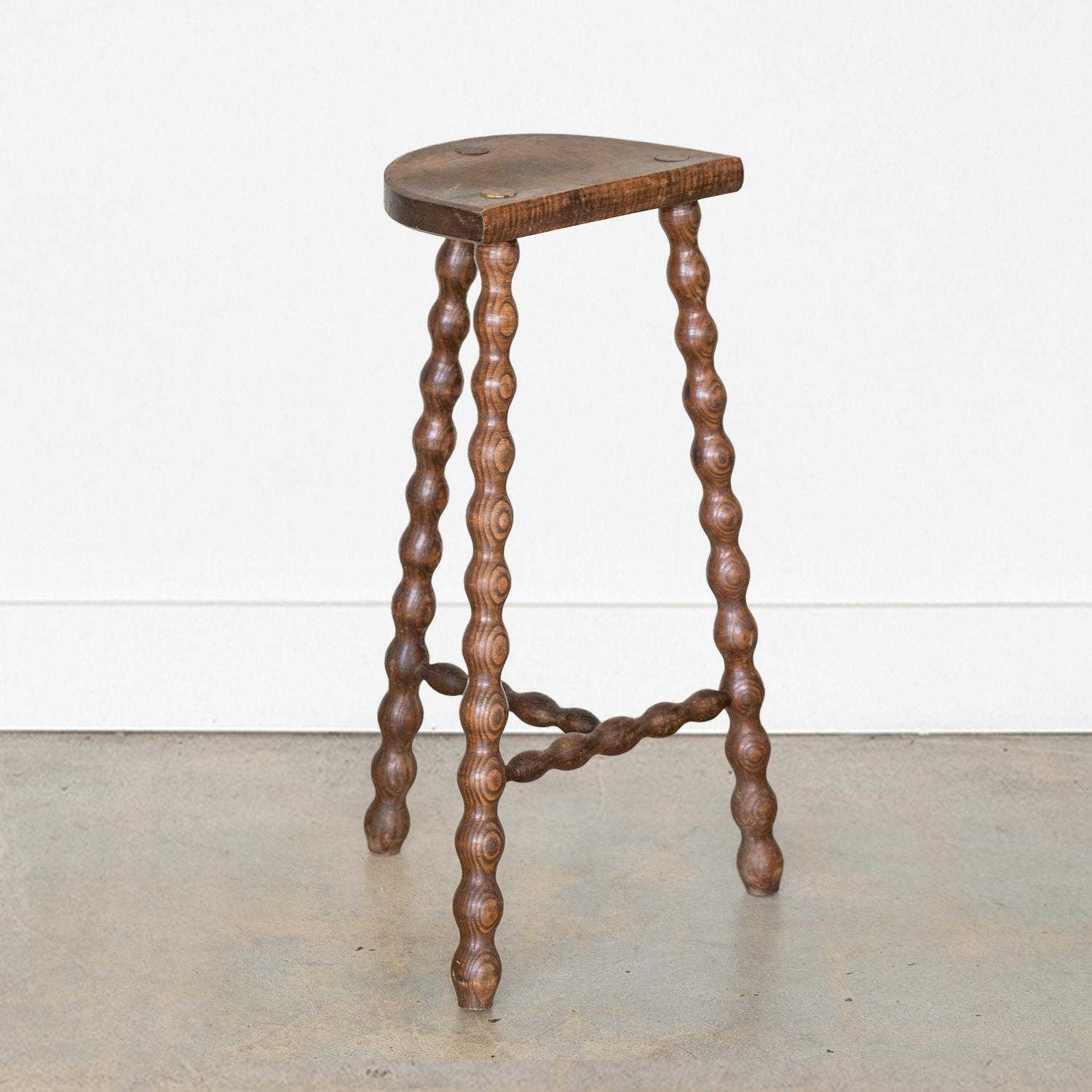Vintage extra tall wood stool with semi-circle seat and wavy tripod legs from France. Original wood finish with great age markings and patina. Can be used as a stool or as side table. 



