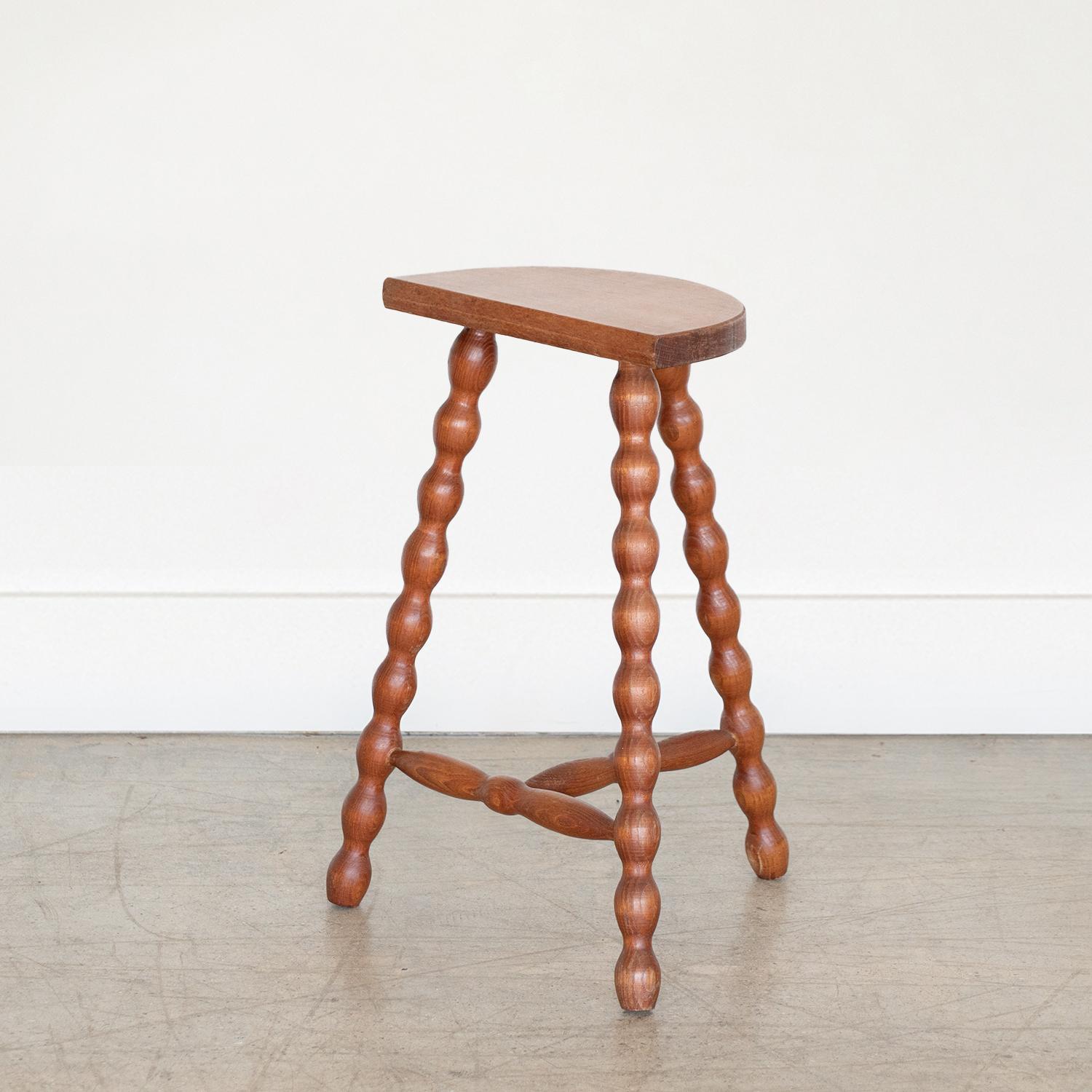 Vintage tall wood stool with semi-circle seat and wavy tripod legs from France. Original finish shows great age and patina. Can be used as a stool or as side table. 



