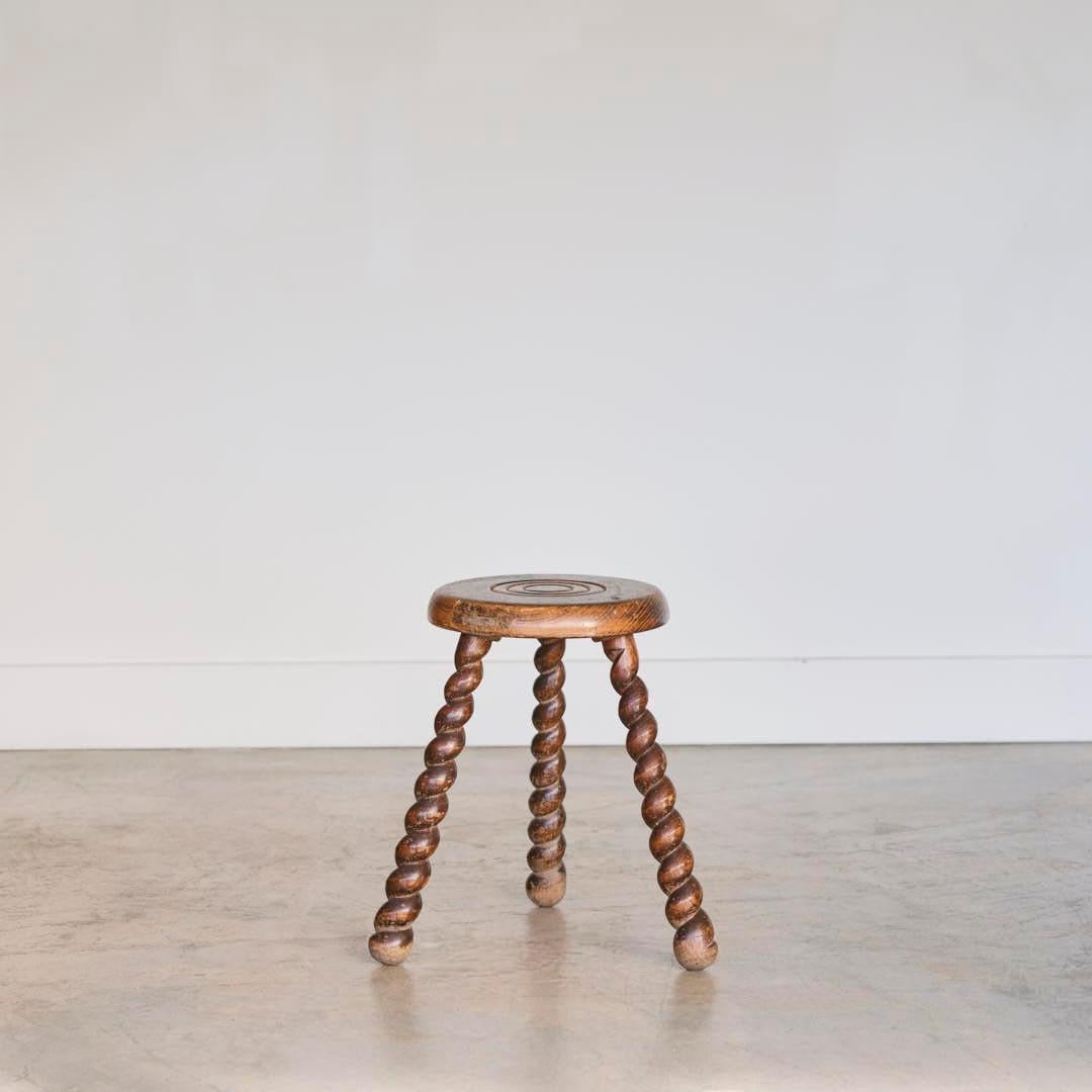 Unique vintage stool with circular seat and twisted tripod legs from France. Circular seat has beautiful carved ring detail on top. Original wood finish with great age markings and patina. Can be used as a stool or as side table next to chairs.