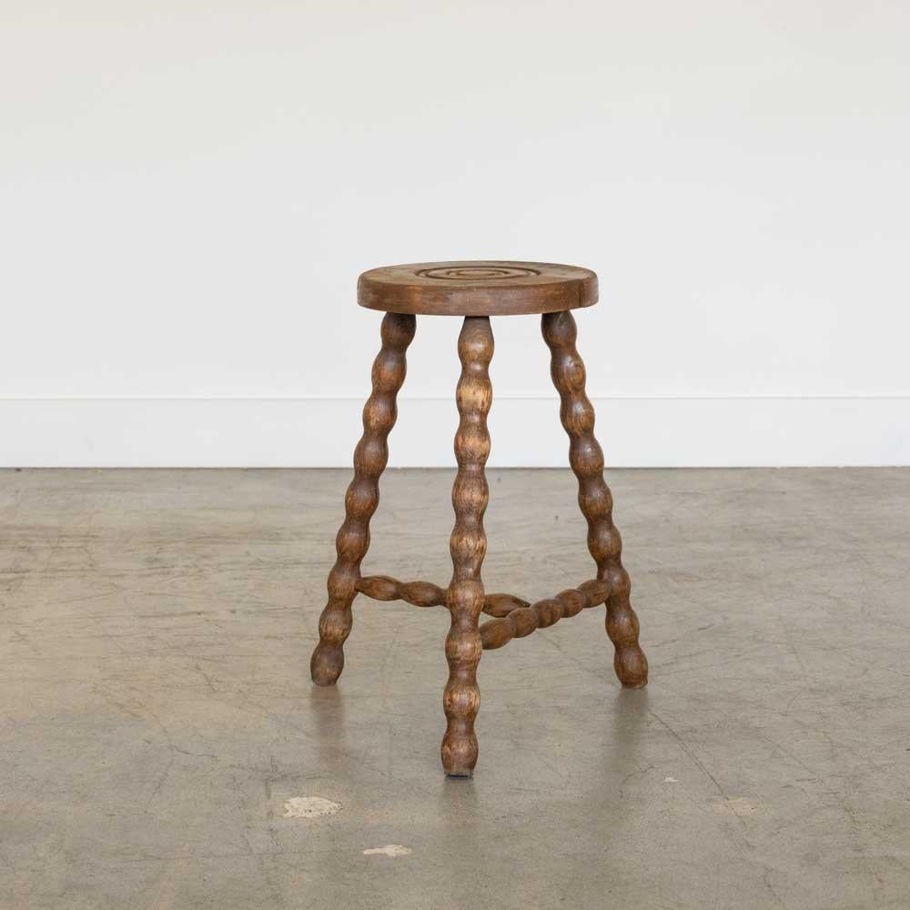 Sgabello vintage in legno con belle gambe in legno ondulato proveniente dalla Francia. Sedile circolare con particolare anello intagliato sulla parte superiore. Finitura originale in legno con bei segni dell'età e patina. Può essere utilizzato come