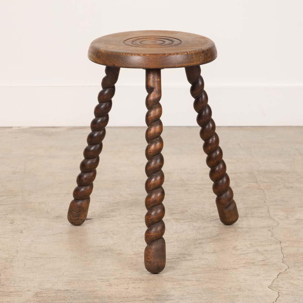 Unique vintage stool with circular seat and twisted tripod legs from France. Circular seat has beautiful carved ring detail on top. Original wood finish with nice age markings and patina. Can be used as a stool or as side table next to chairs.