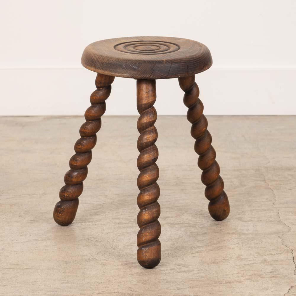 Unique vintage stool with circular seat and twisted tripod legs from France. Circular seat has beautiful carved ring detail on top. Original wood finish with nice age markings and patina. Can be used as a stool or as side table next to chairs.