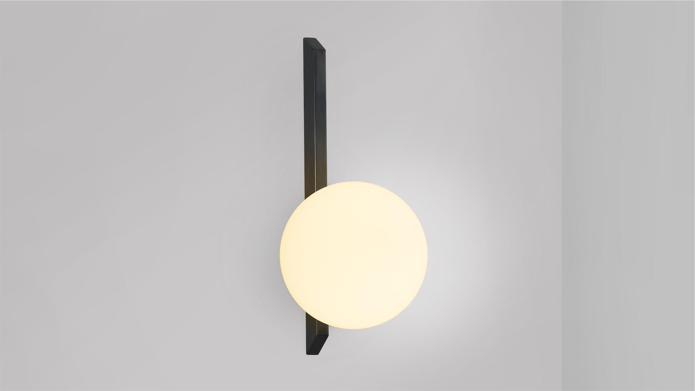 Tall Gaia wall lamp by CTO Lighting
Materials: Bronze with matt opal glass.
Dimensions: D 18.3 x W 15 x H 35 cm
Available in bronze or satin brass and in hand shaped smoke glass, matte opal glass, shiny opal glass, or tinted glass.

An elegant