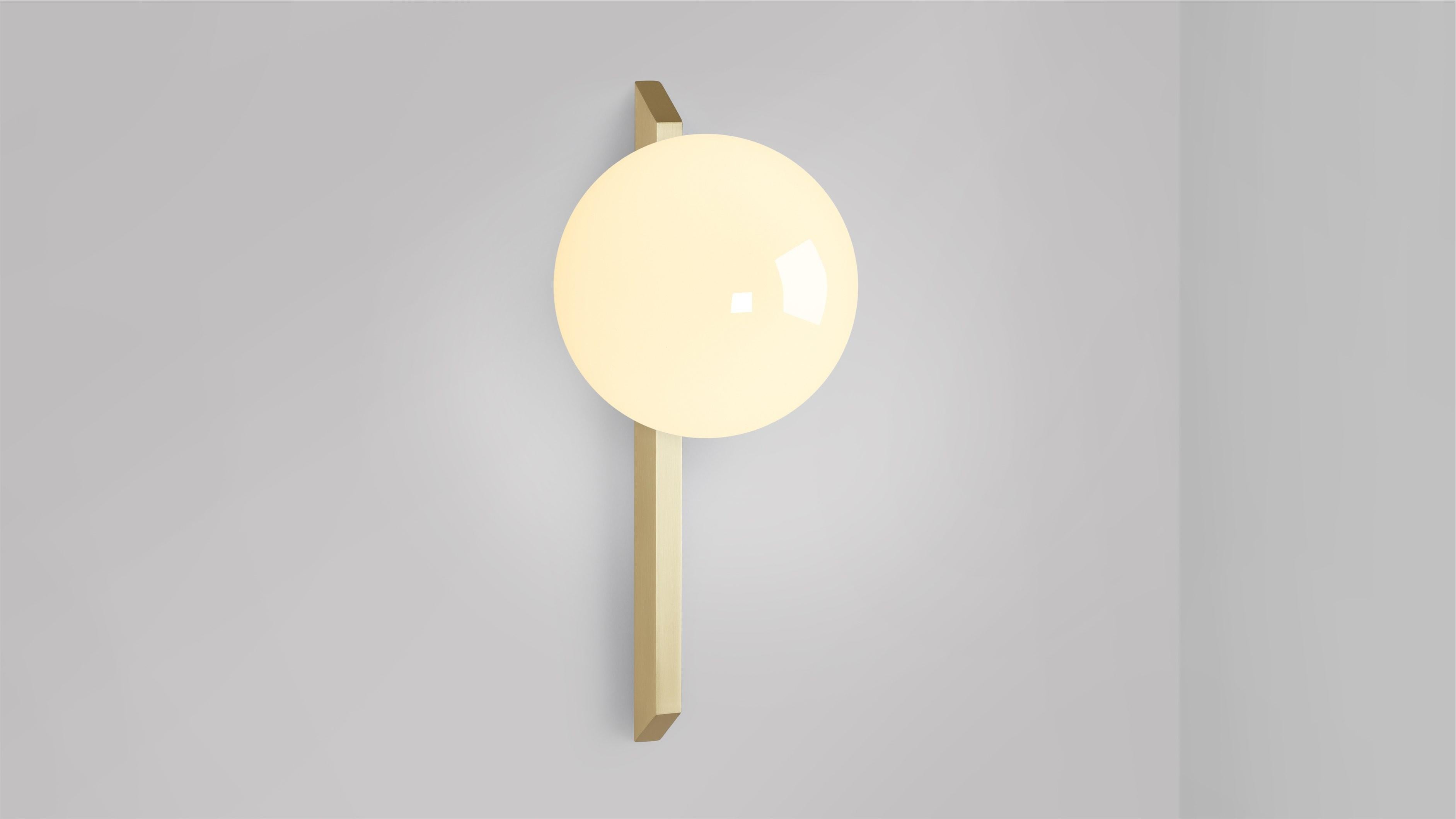 Tall Gaia wall lamp by CTO Lighting
Materials: Satin brass with shiny opal glass.
Dimensions: D 18.3 x W 15 x H 35 cm
Available in bronze or satin brass and in hand shaped smoke glass, matte opal glass, shiny opal glass, or tinted glass.

An elegant