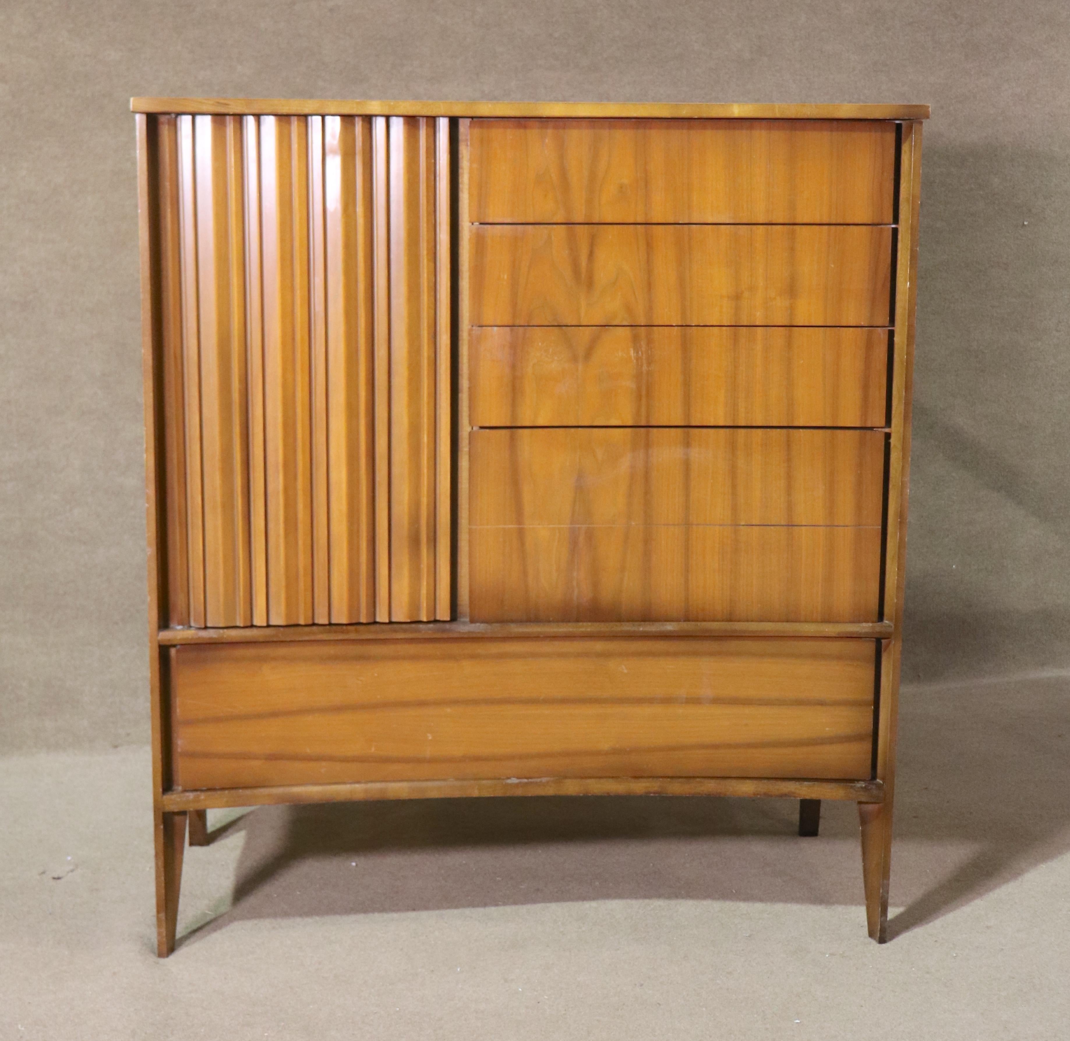 Grande commode en noyer du milieu du siècle avec un plateau incurvé unique. Neuf tiroirs au total, dont quatre cachés par une porte sculptée et un grand tiroir inférieur. Les pieds fuselés terminent la construction bien conçue.
Veuillez confirmer le