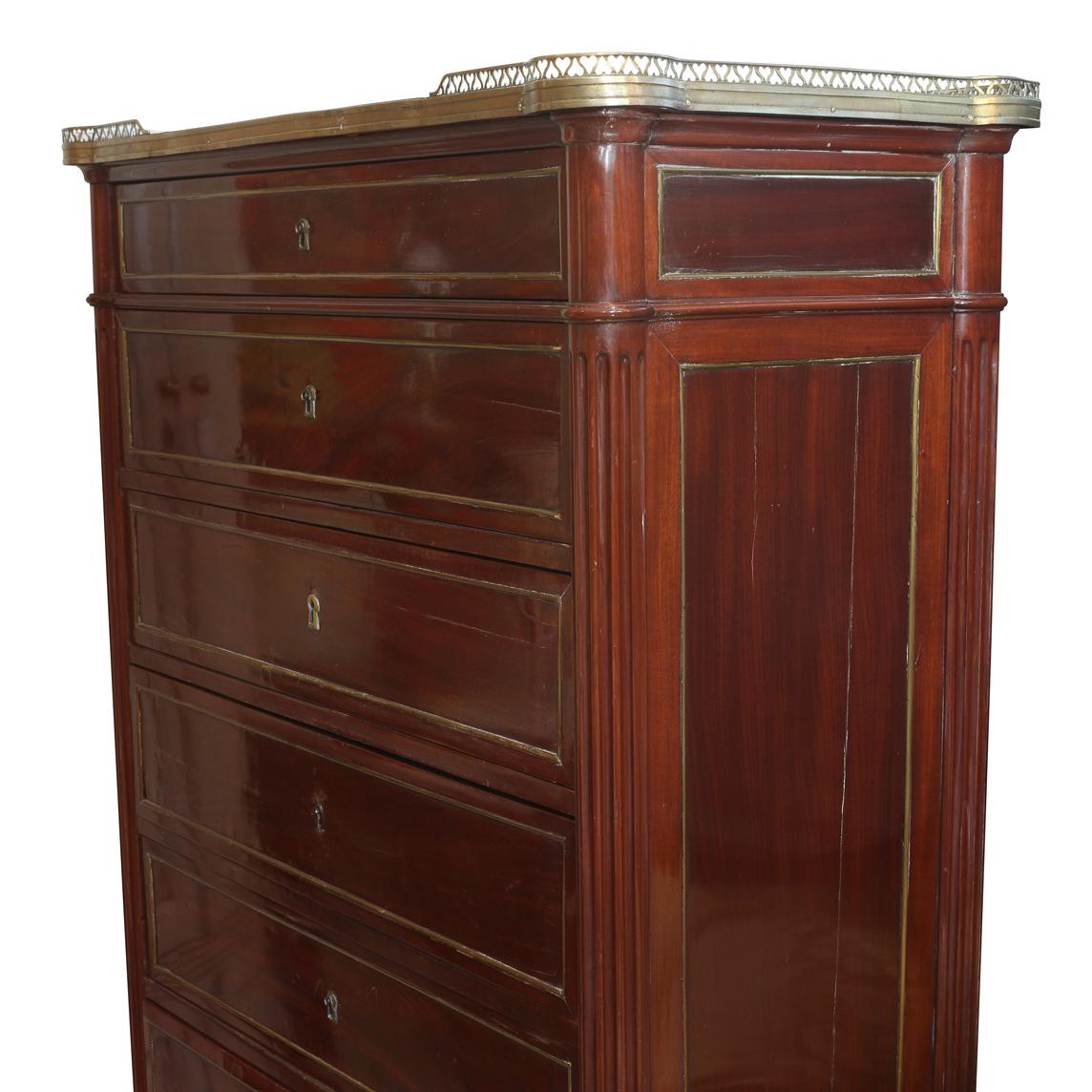 A vintage eight drawer gentleman's chest with a pierced brass rail and marble top.