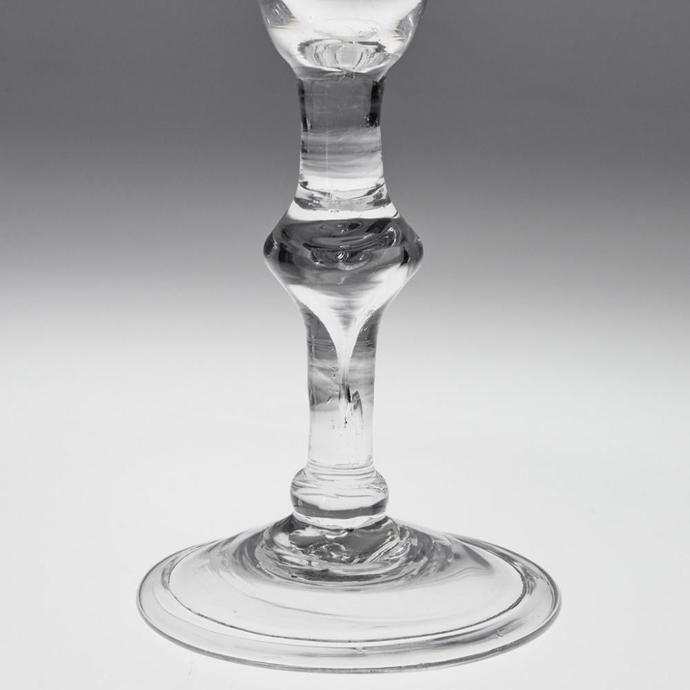 Tall Georgian Balustroid Wine Glass, c1750

Additional information:
Period : George II
Origin : England 
Colour : Clear 
Bowl : Bell-shaped with strong pucella marks
Stem : Plain with a medial angular knop containing a large tear extending down
