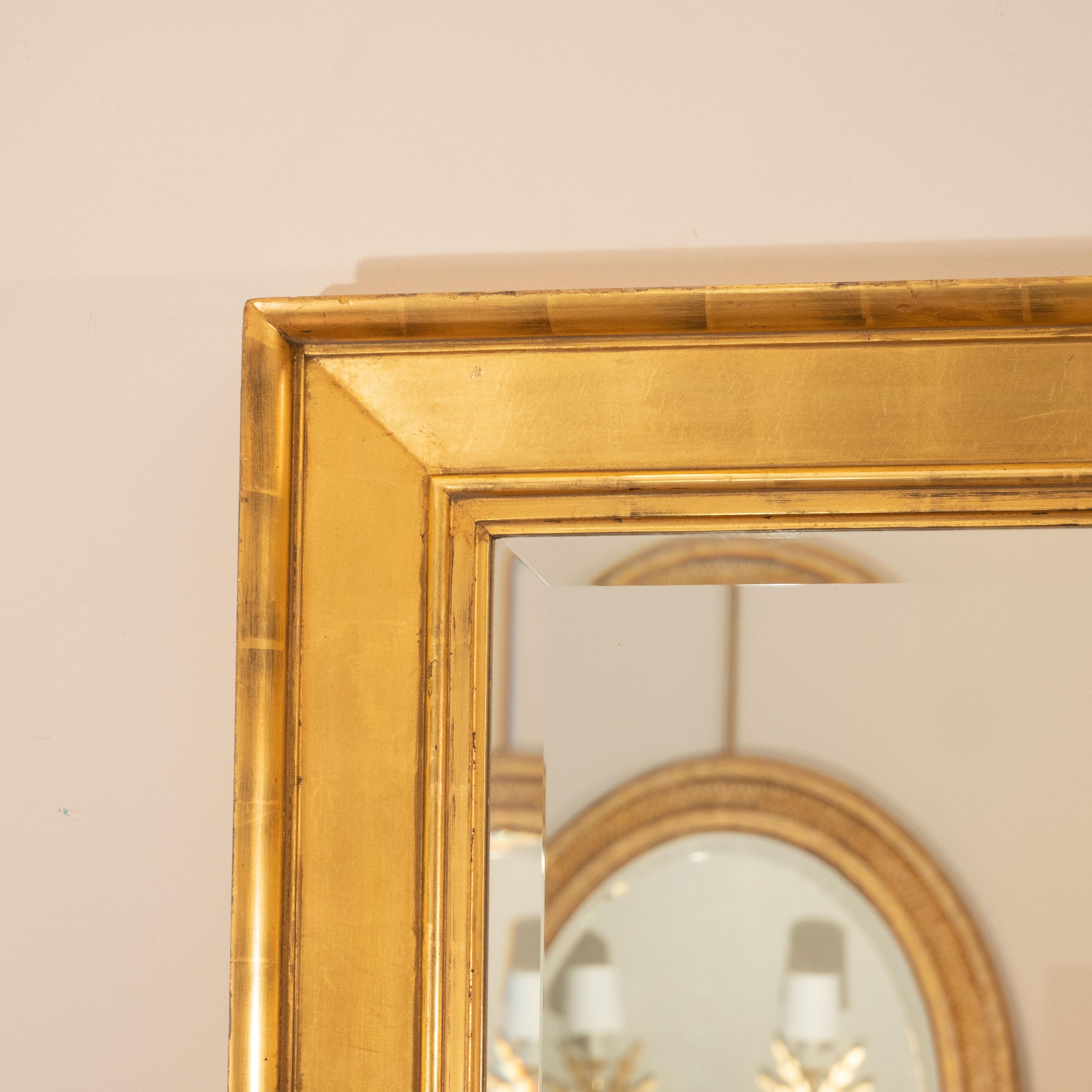A late 19th century water-gilt frame with a later bevelled mirror. This beauty has aged to a wonderful warm finish and has exquisite molded detail. It will make a dramatic statement in any room!