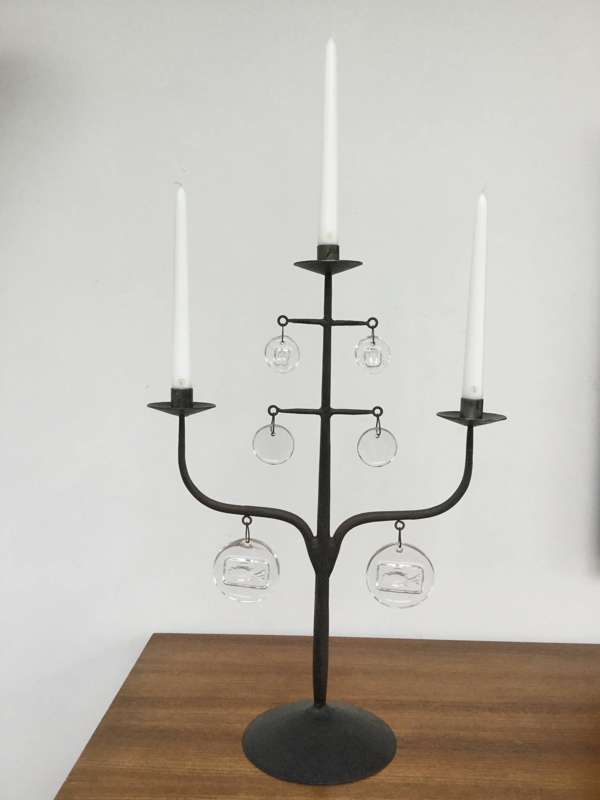 Rough blackened iron candelabrum by Erik Hoglund with various signature handcrafted glass discs with impressed images of fishes and faces. Designed in 1957 for Boda Glassworks. Ironwork by Axel Stromberg, Sweden.
Measure: With candles total height