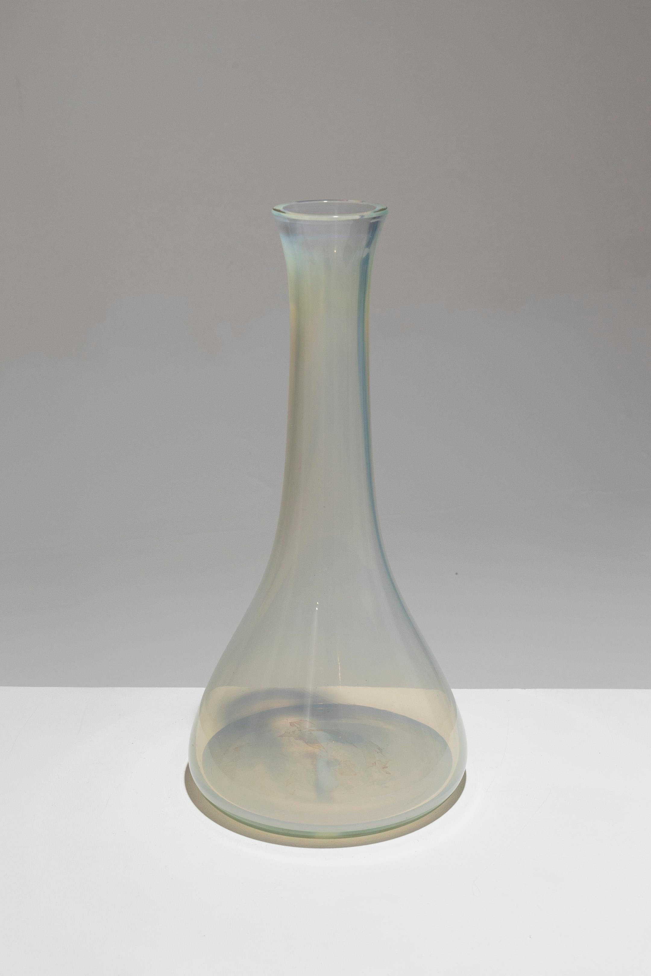 Grand vase en verre épais blanc anis translucide, années 1950. Le verre reflète des teintes ambrées et bleues à l'intérieur. Le col long est légèrement évasé sur le dessus. Bon état.
DV1528