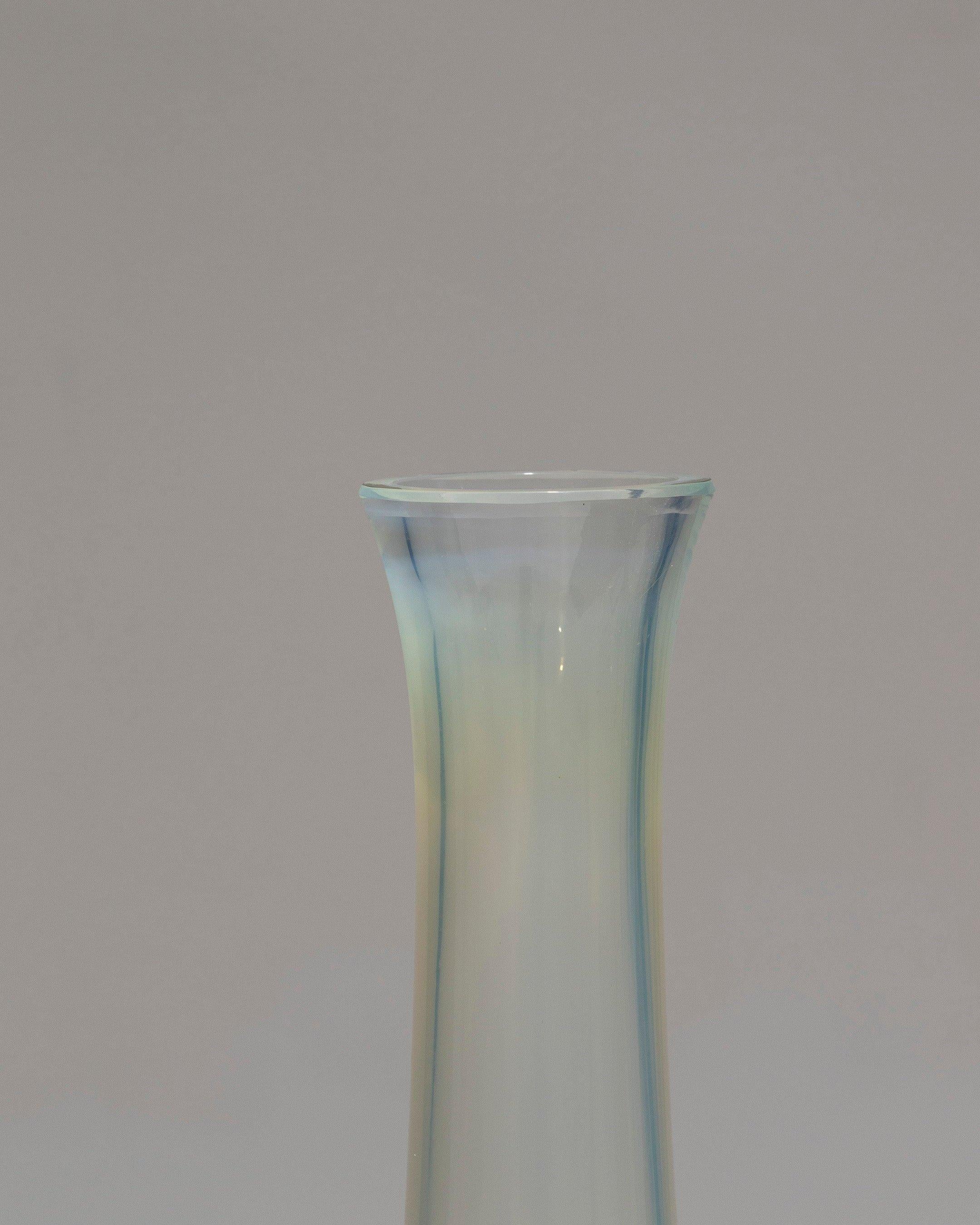 Vaso alto in vetro spesso traslucido color anice e bianco, anni '50. Il vetro riflette sfumature ambrate e blu all'interno. Il collo lungo è delicatamente svasato in alto. Buone condizioni.
DV1528