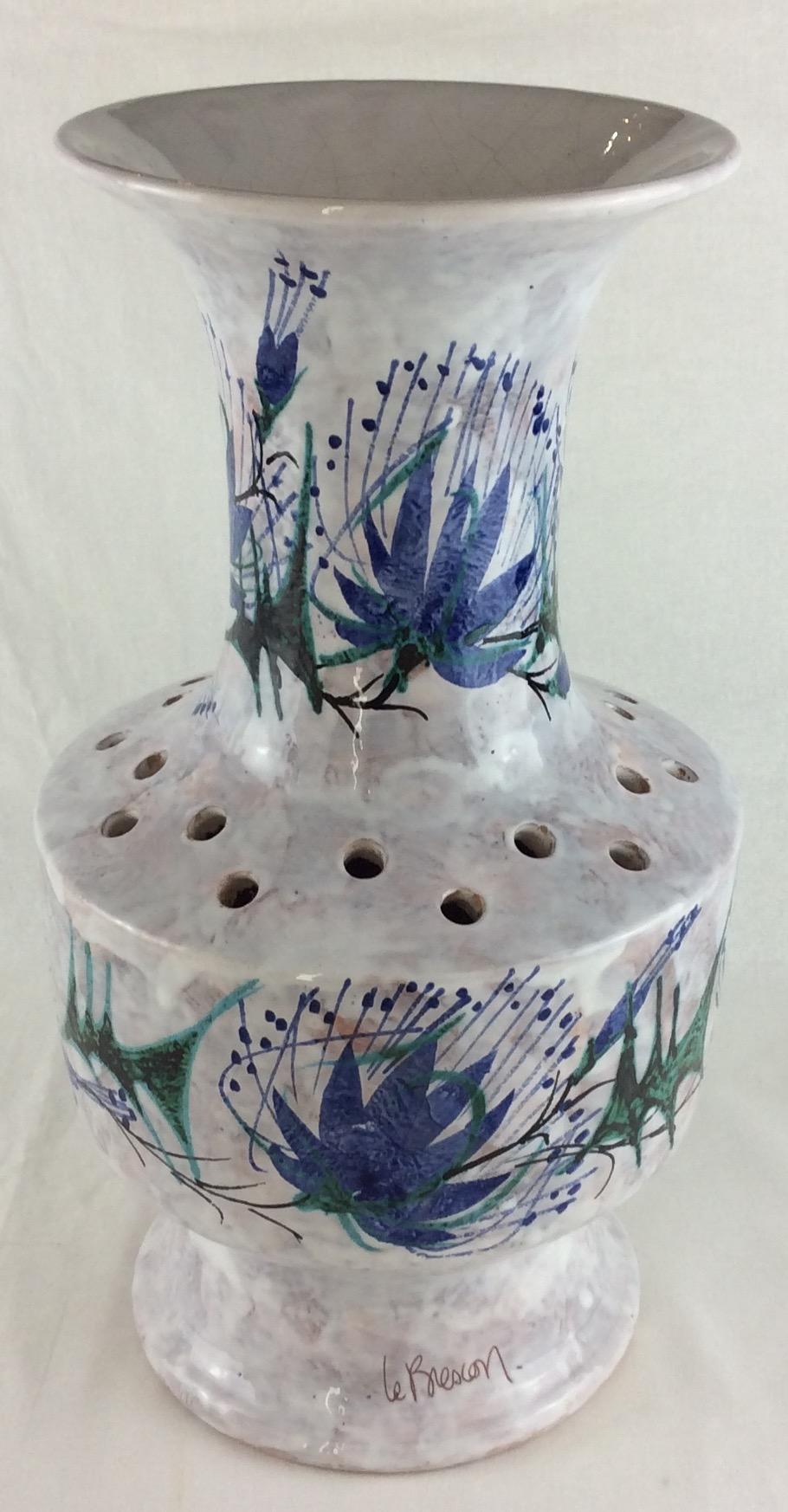 A fine midcentury vase from Vallauris, France signed Le Brescon.
Handcrafted with great precision. The white background is adorned with multicolored flowers and other interesting images, predominantly blue making this piece very pleasing to the